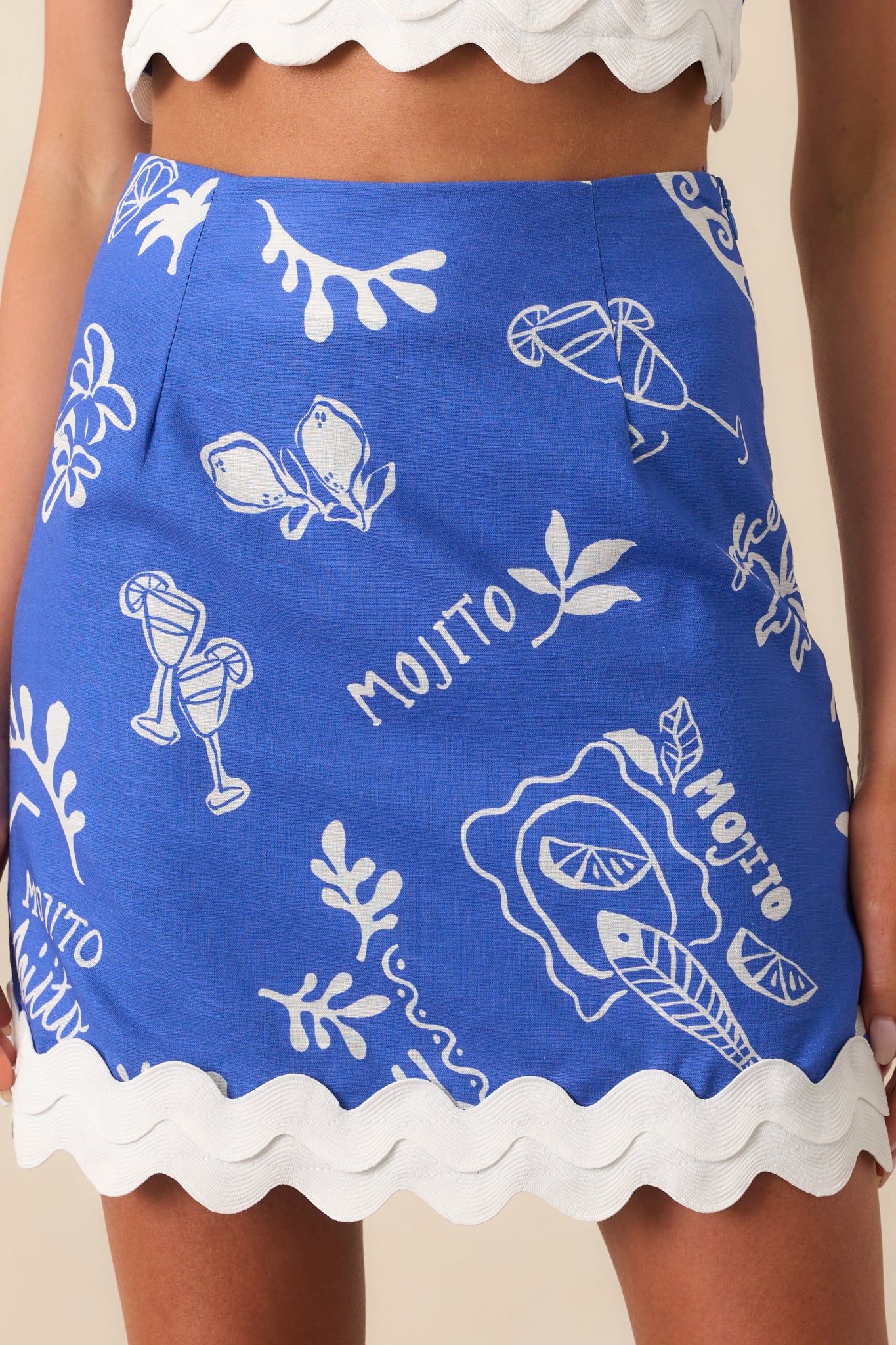 White ric rac trim and vibrant mojito pattern highlighted near the hem of the blue skirt.