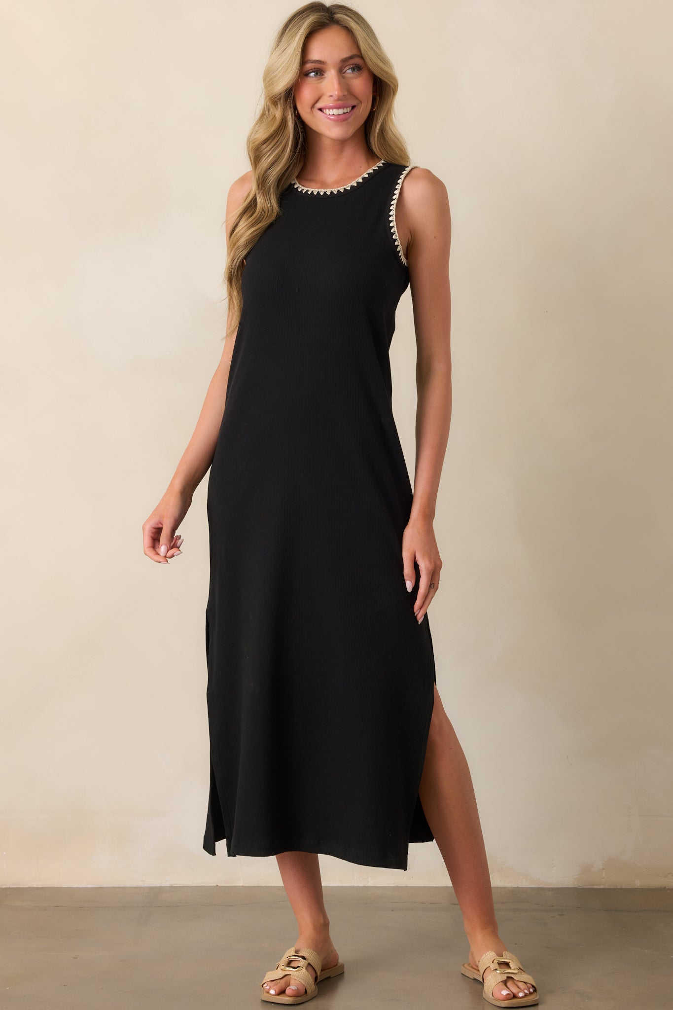 Black midi dress with a round neckline and sleeveless cut, featuring a relaxed silhouette and ivory whip stitch trim.