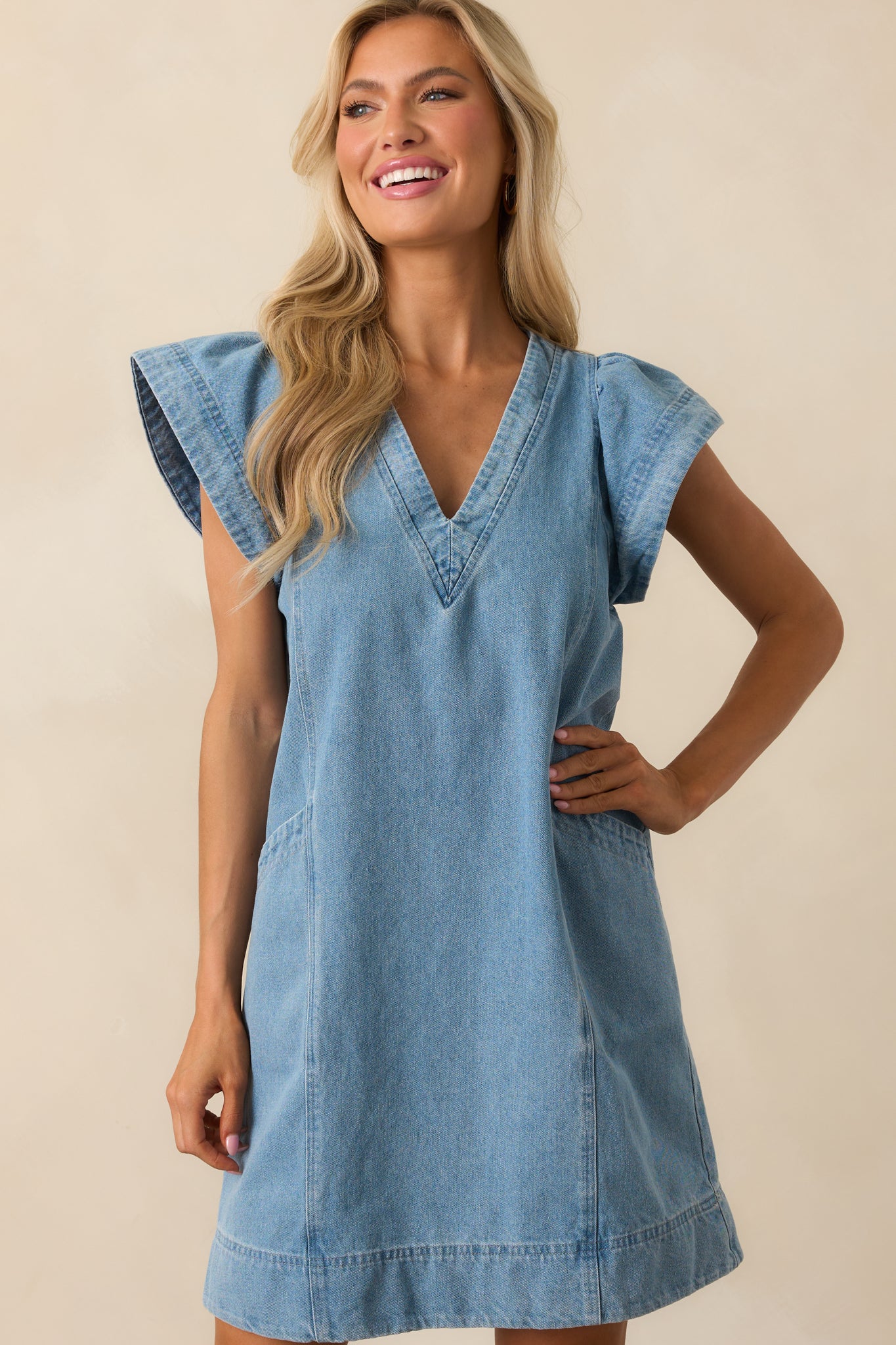 A focused shot of the denim mini dress highlighting its flared silhouette and v-neckline.