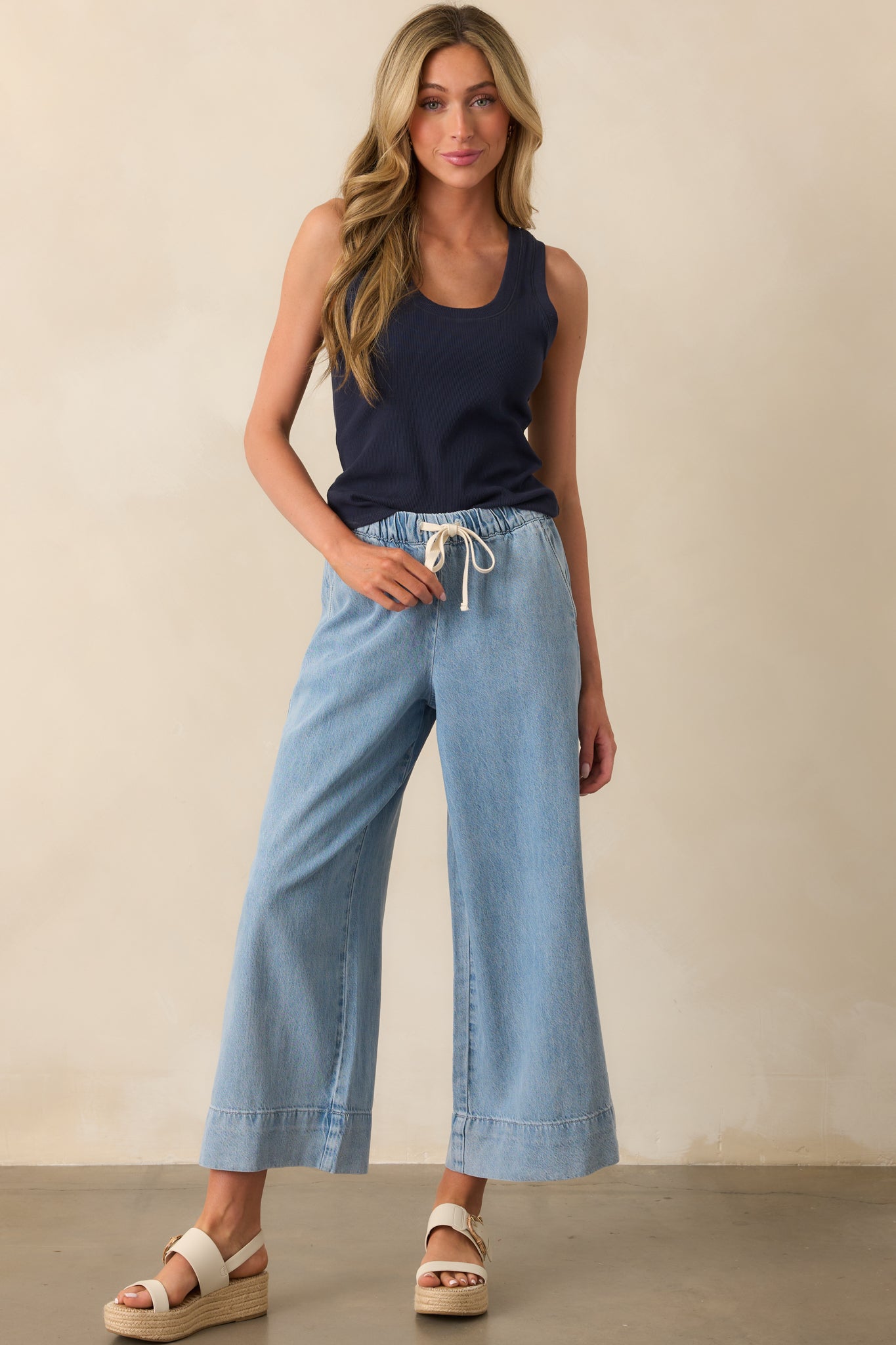 Full view of the light wash pants featuring a high rise and wide leg silhouette in lightweight fabric.