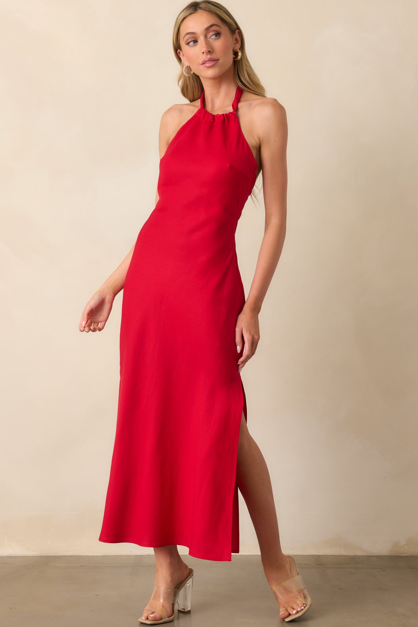 Full view of the red maxi dress displaying the side slit detail and fluid motion of the fabric.