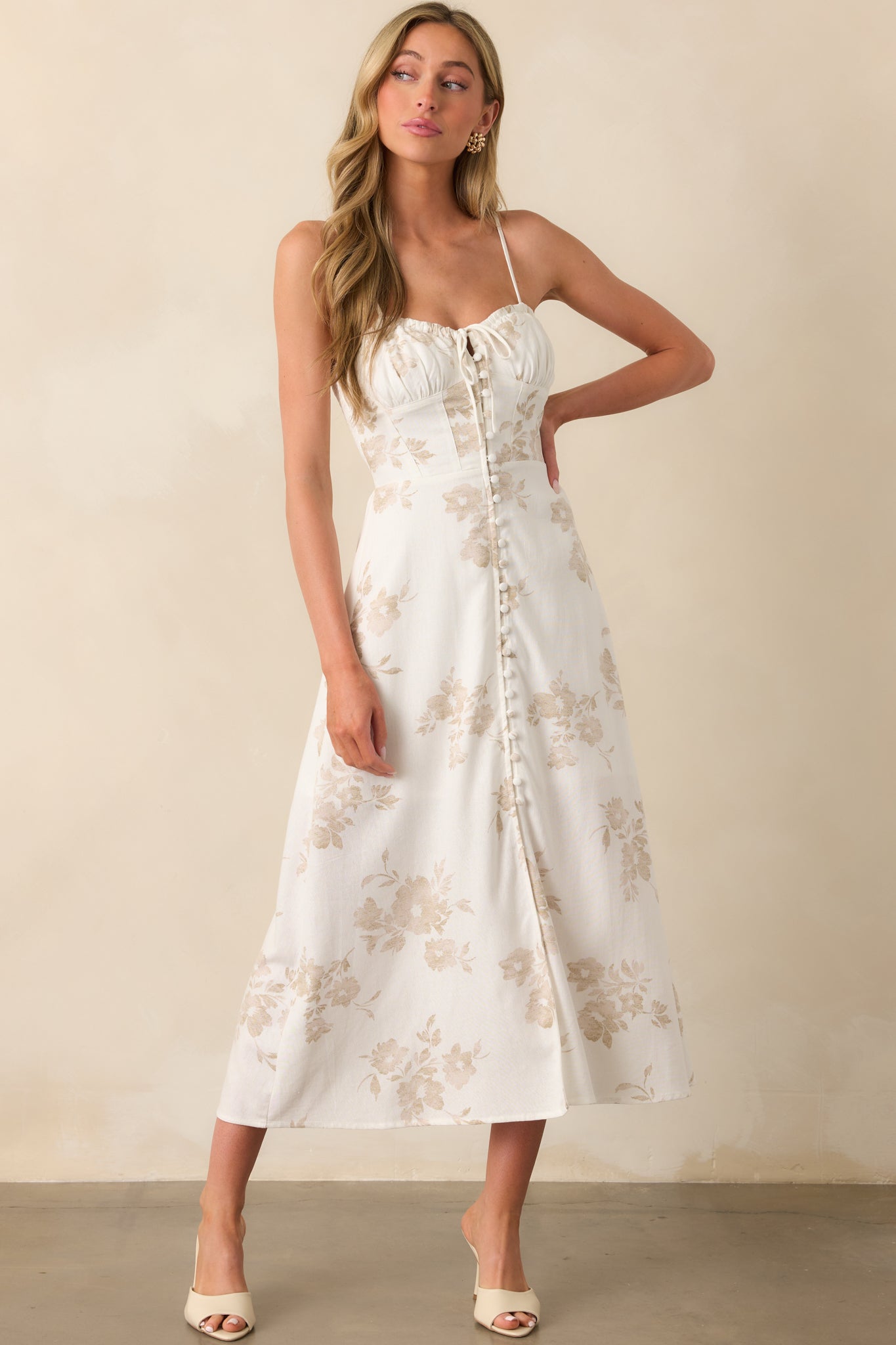Front angle of the beige floral dress featuring the self-tie sweetheart neckline and white lining peeking through.