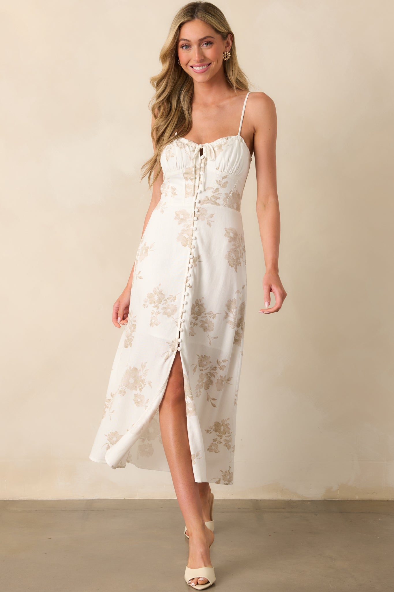 Full view of the ivory maxi dress from the front, displaying the functional buttons and soft floral detailing.