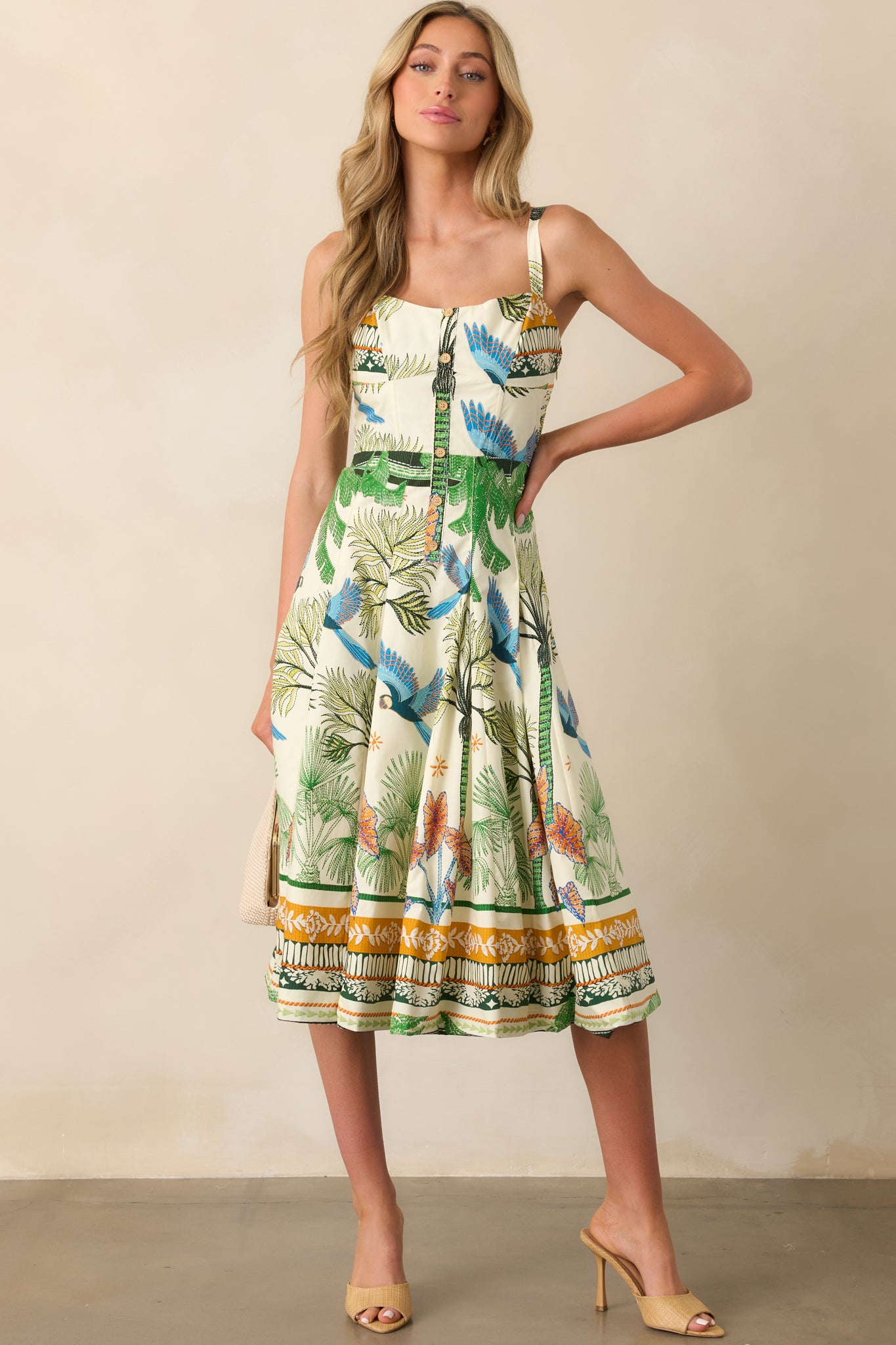 Full-body shot highlighting the faux button front and pleated skirt of the tropical print dress.