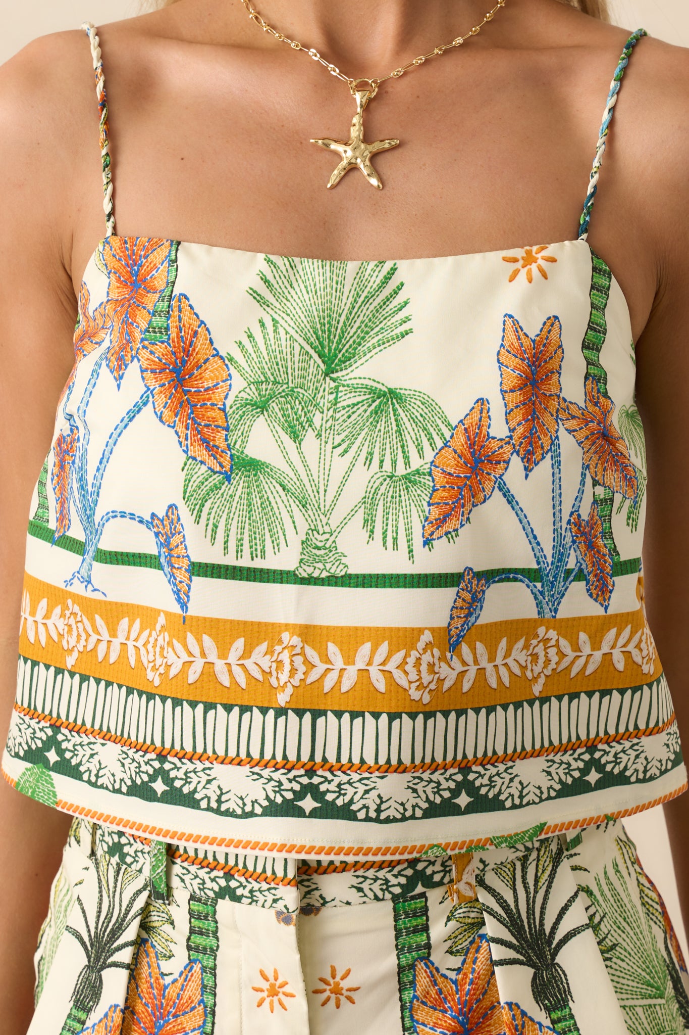 Close-up detail of the tropical print fabric and twist strap design, showing texture and color vibrancy.
