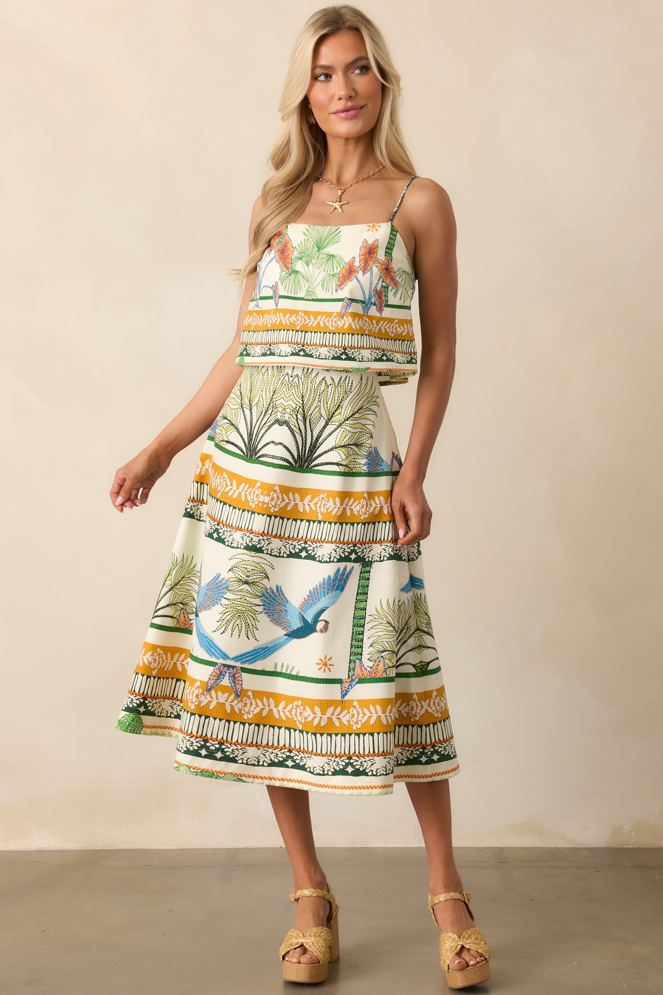 Full view of the ivory tropical print top, highlighting its cropped length and colorful pattern.