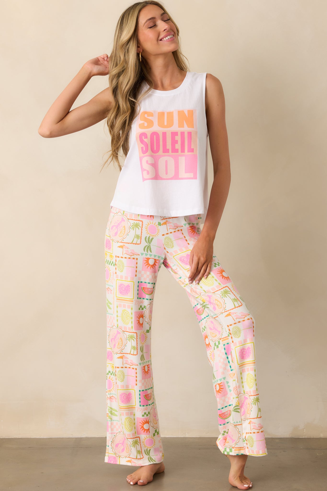 Front-facing full-body image showing the "Sun Soleil Sol" multicolor graphic print on the front of the white tank.