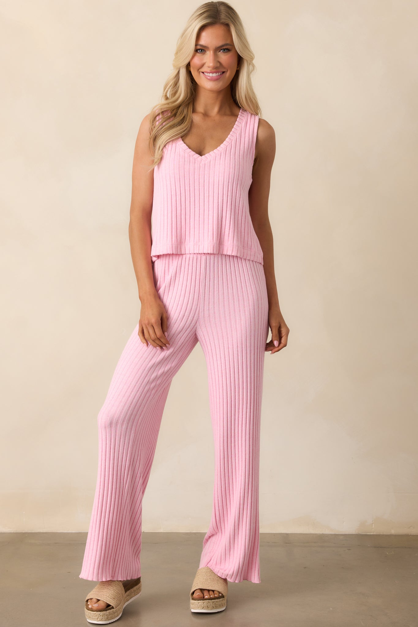 A full view of the pink sleeveless top showcasing its v-neckline and wide, bra-friendly shoulder straps.