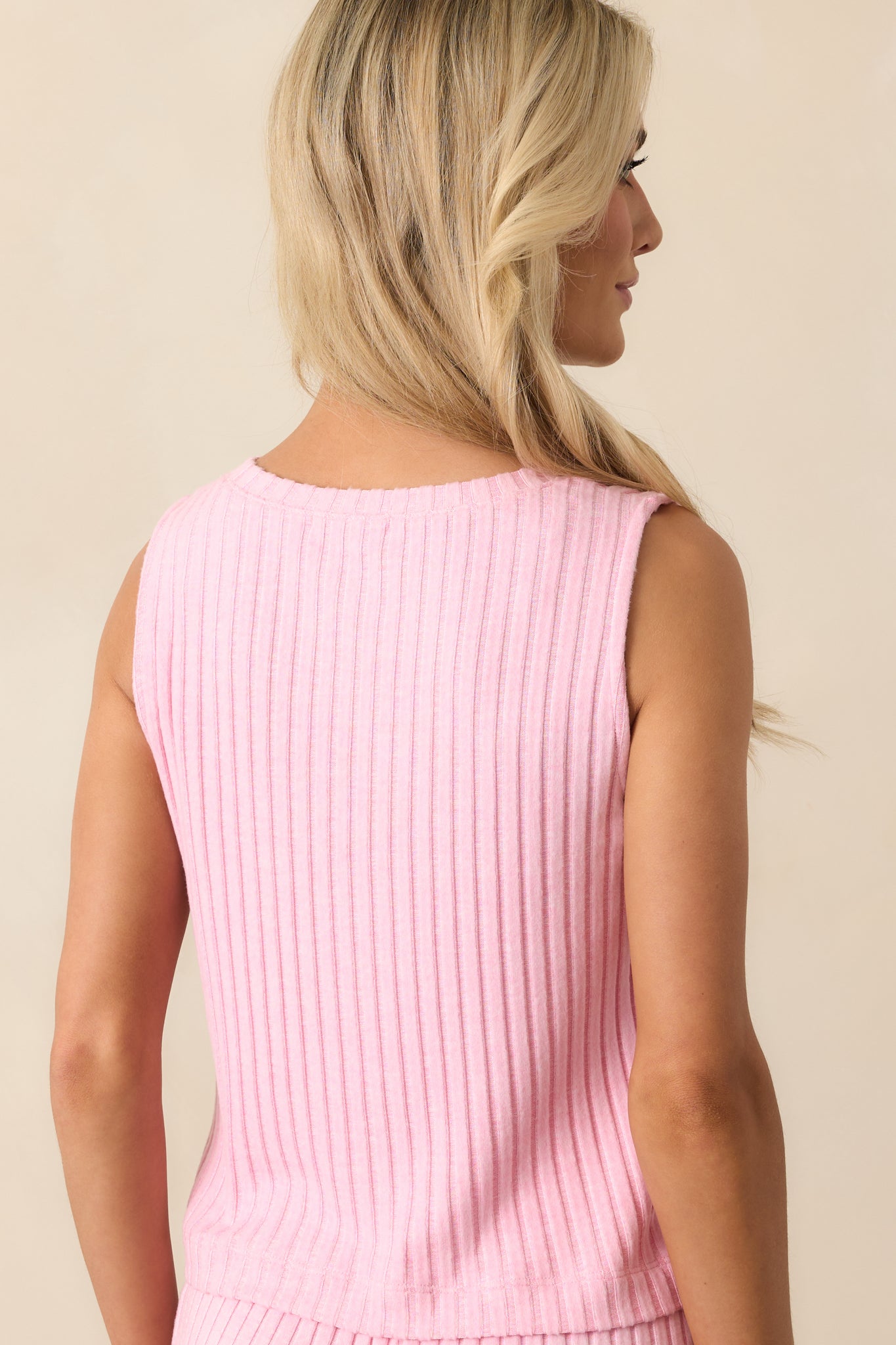 A view from behind of the pink sleeveless top, showing the wide straps and ribbed fabric texture.