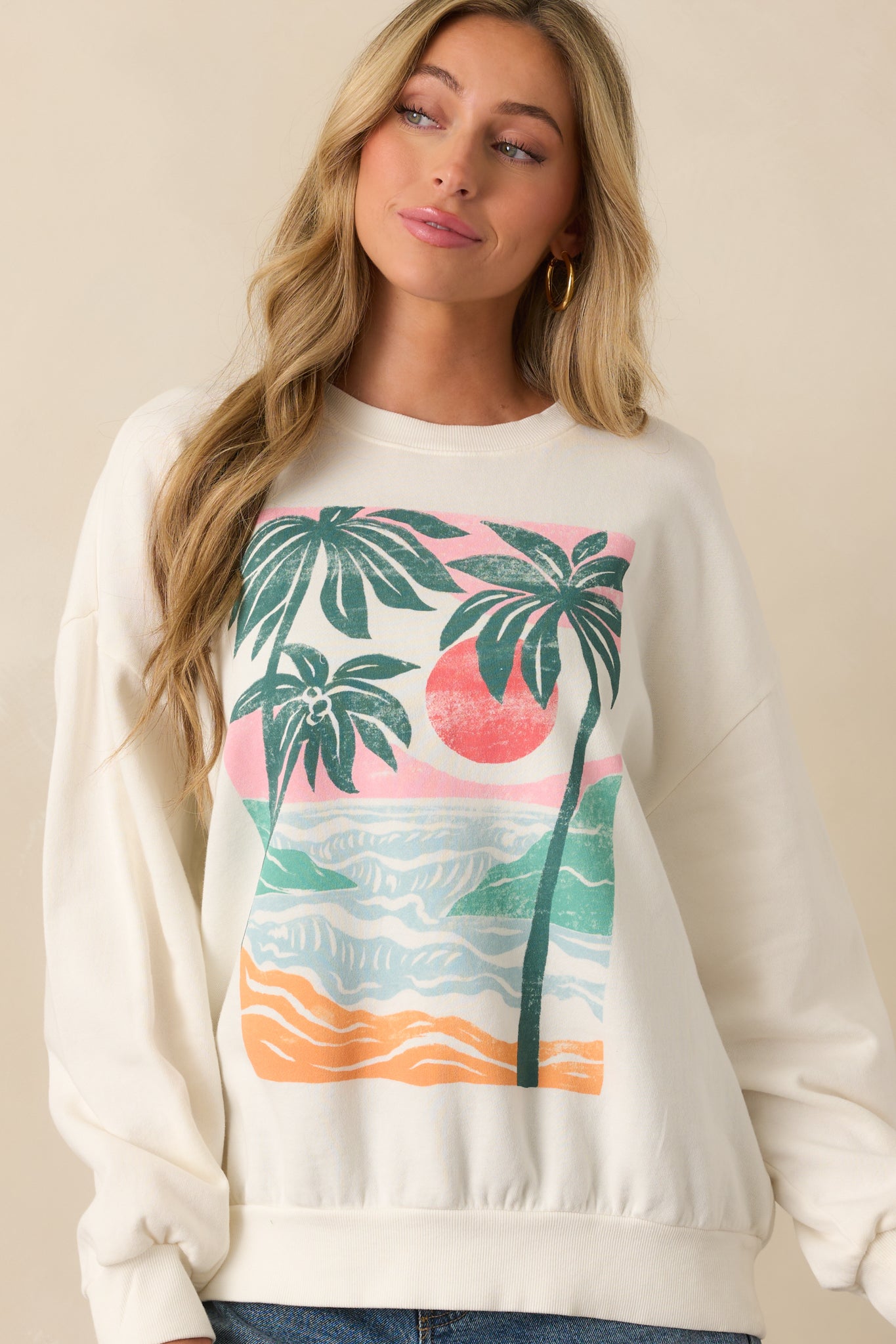 Partial front view showcasing the vivid graphic print and soft fabric of the ivory sweatshirt.