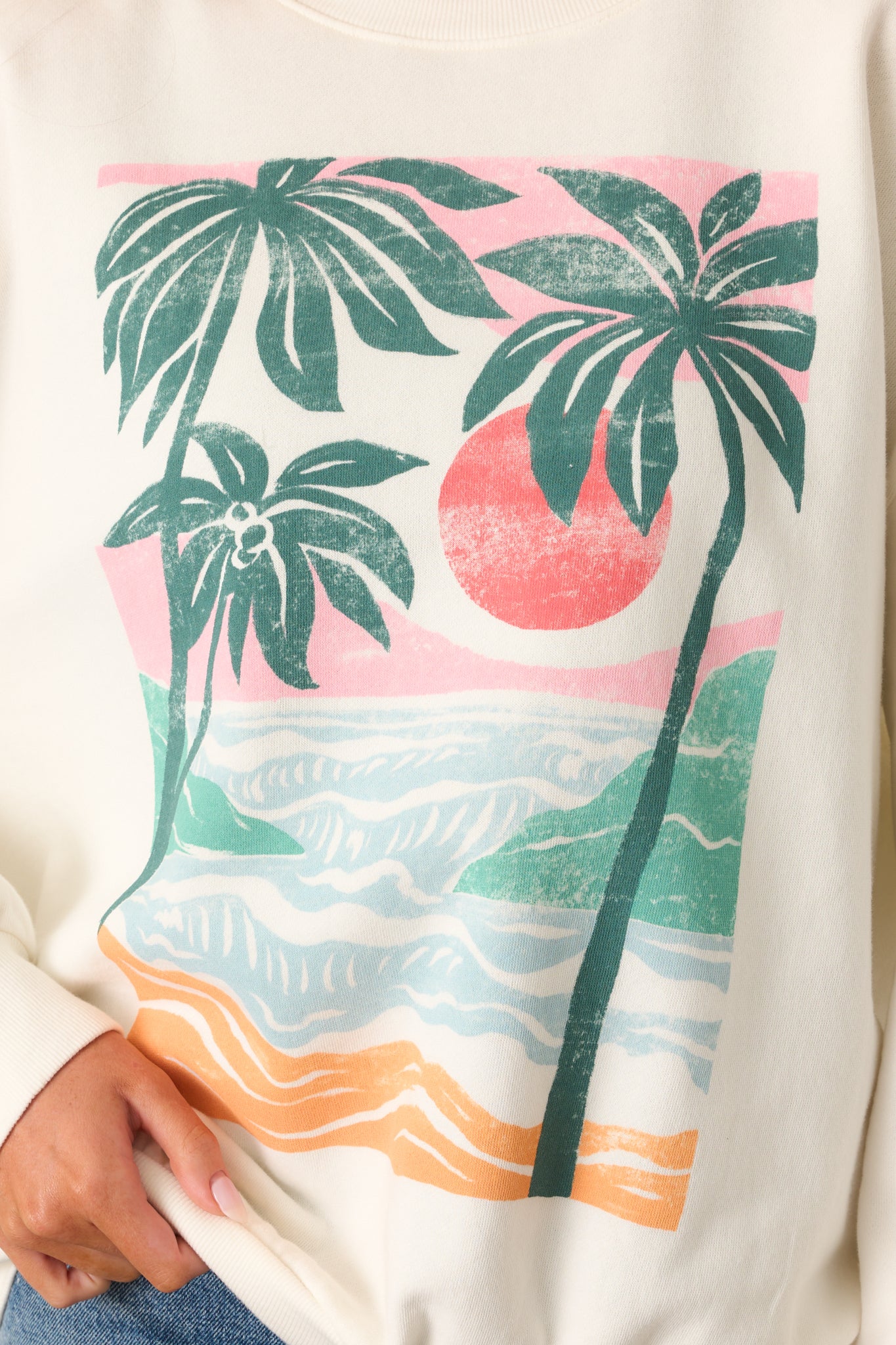 Zoomed-in shot of the beach graphic on the front of the sweatshirt, showing detailed colors and texture.