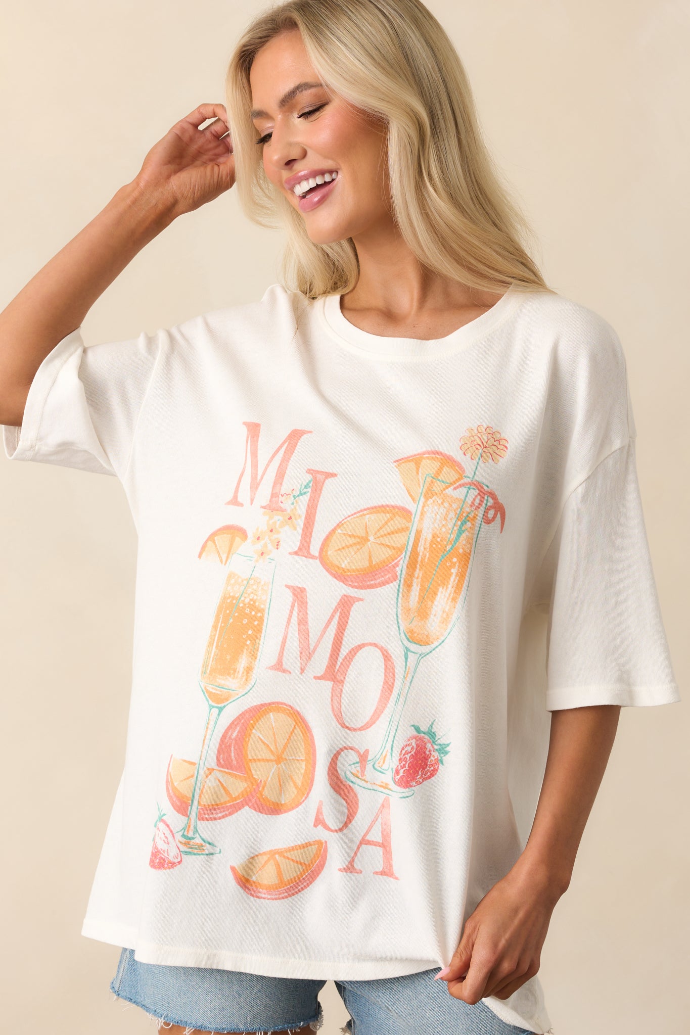 Oversized ivory tee shown in a full-length image, featuring short sleeves and bold front graphic.