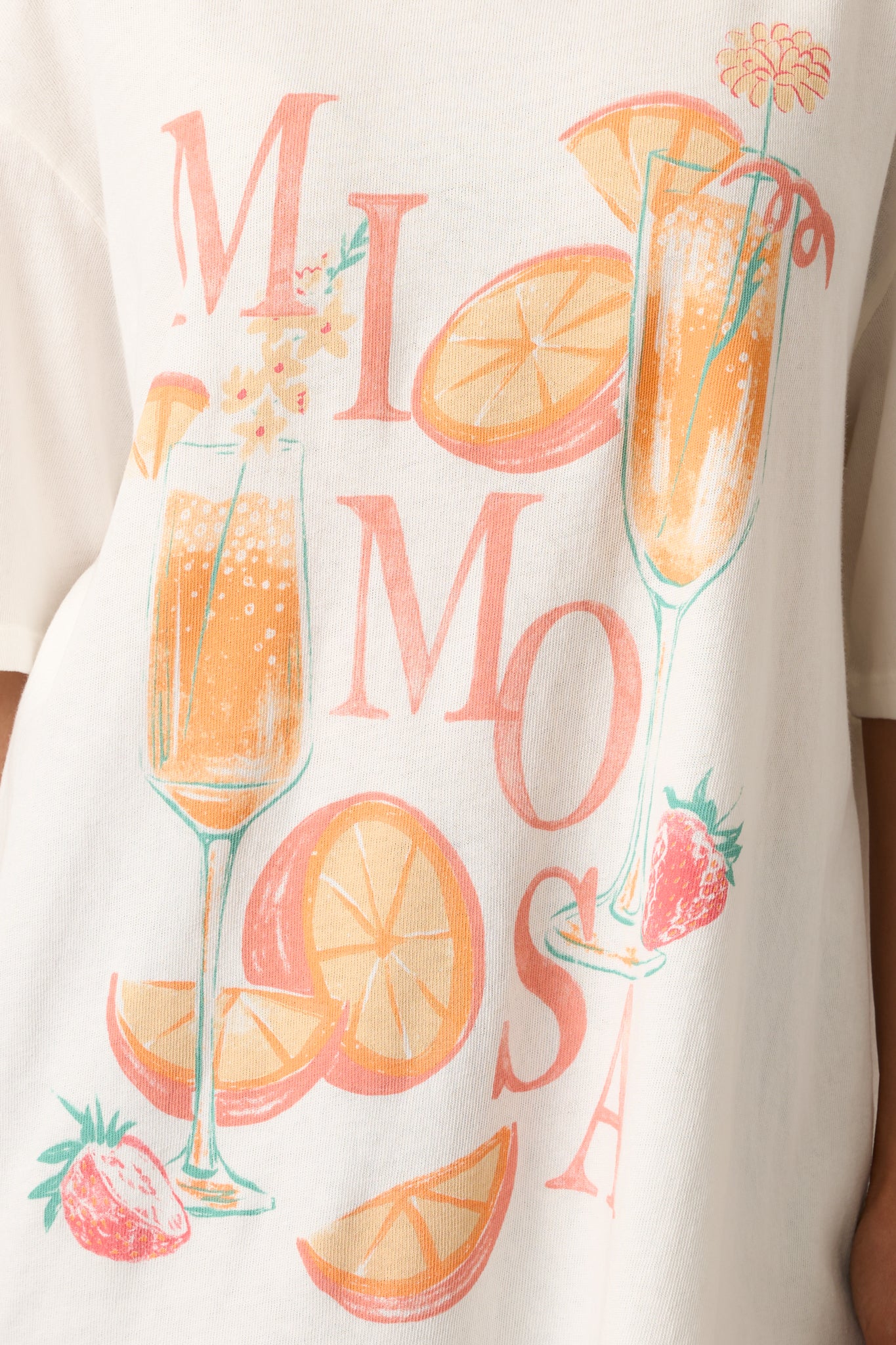 Close-up detail of the ivory tee’s "Mimosa" screen print, revealing color and print texture on the soft fabric.