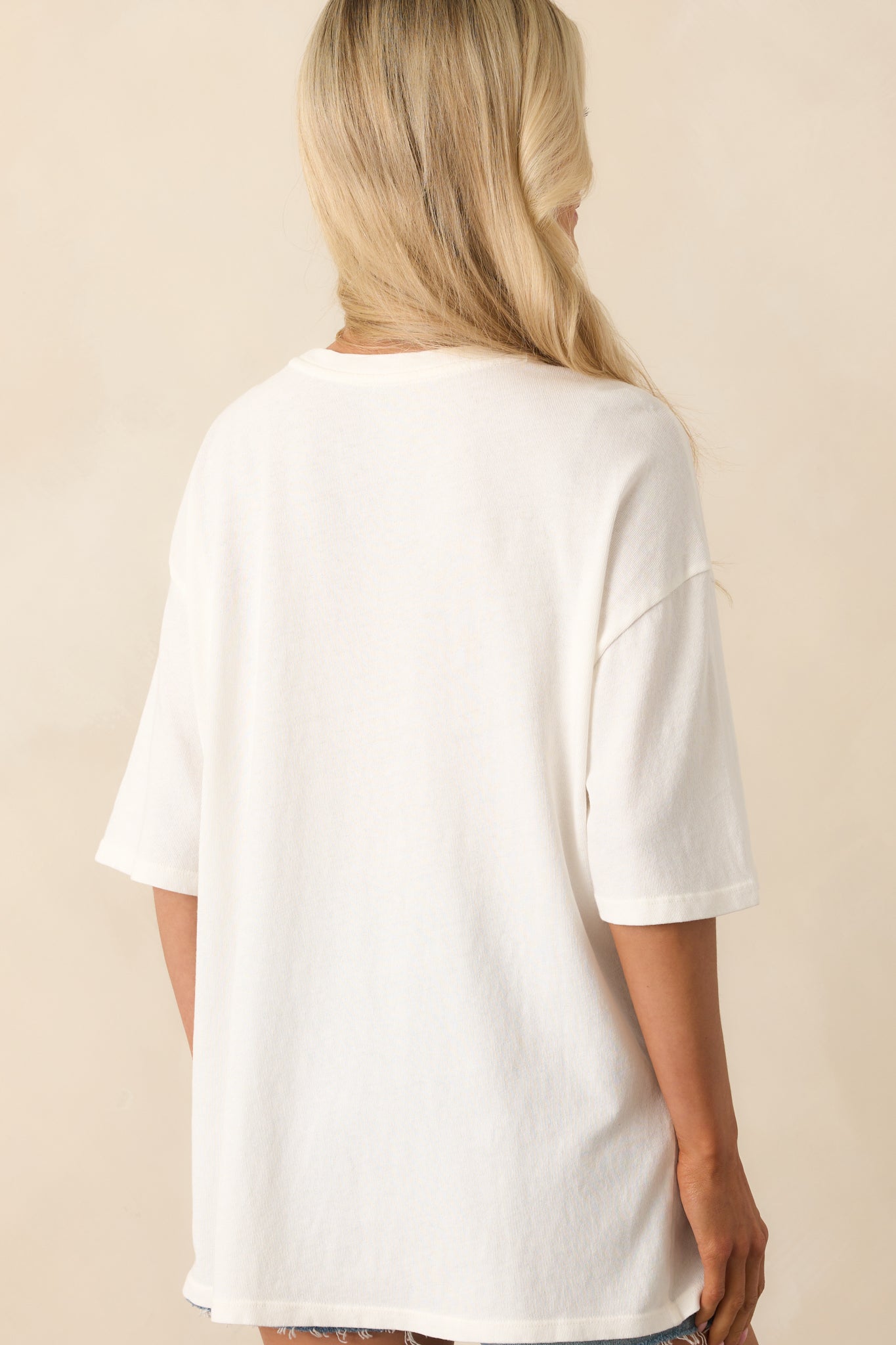 A view from behind of the ivory oversized tee, showing the drape and flow of the lightweight fabric.
