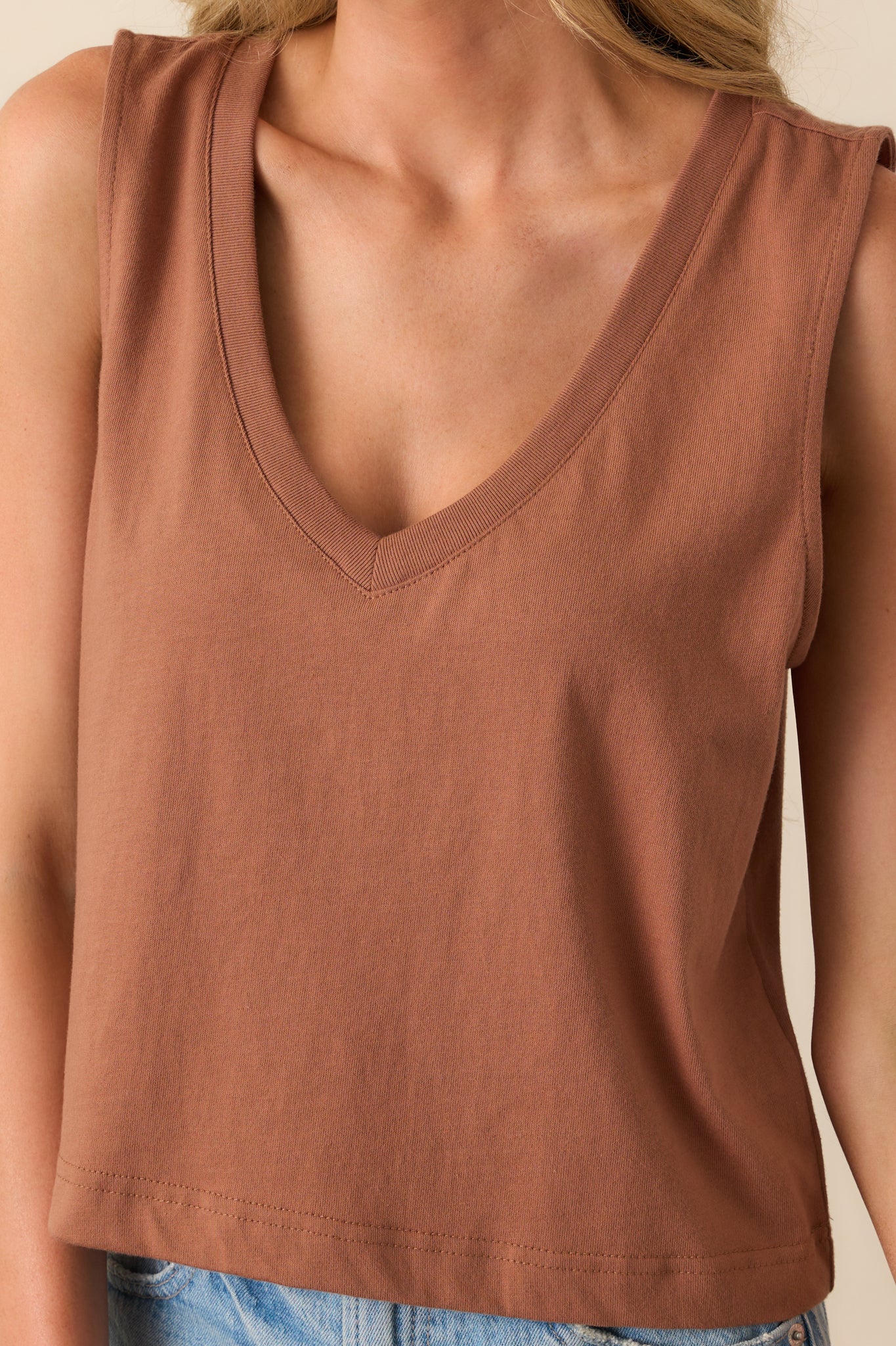 Detailed shot of the fabric texture and V-neck stitching of the brown sleeveless tank.