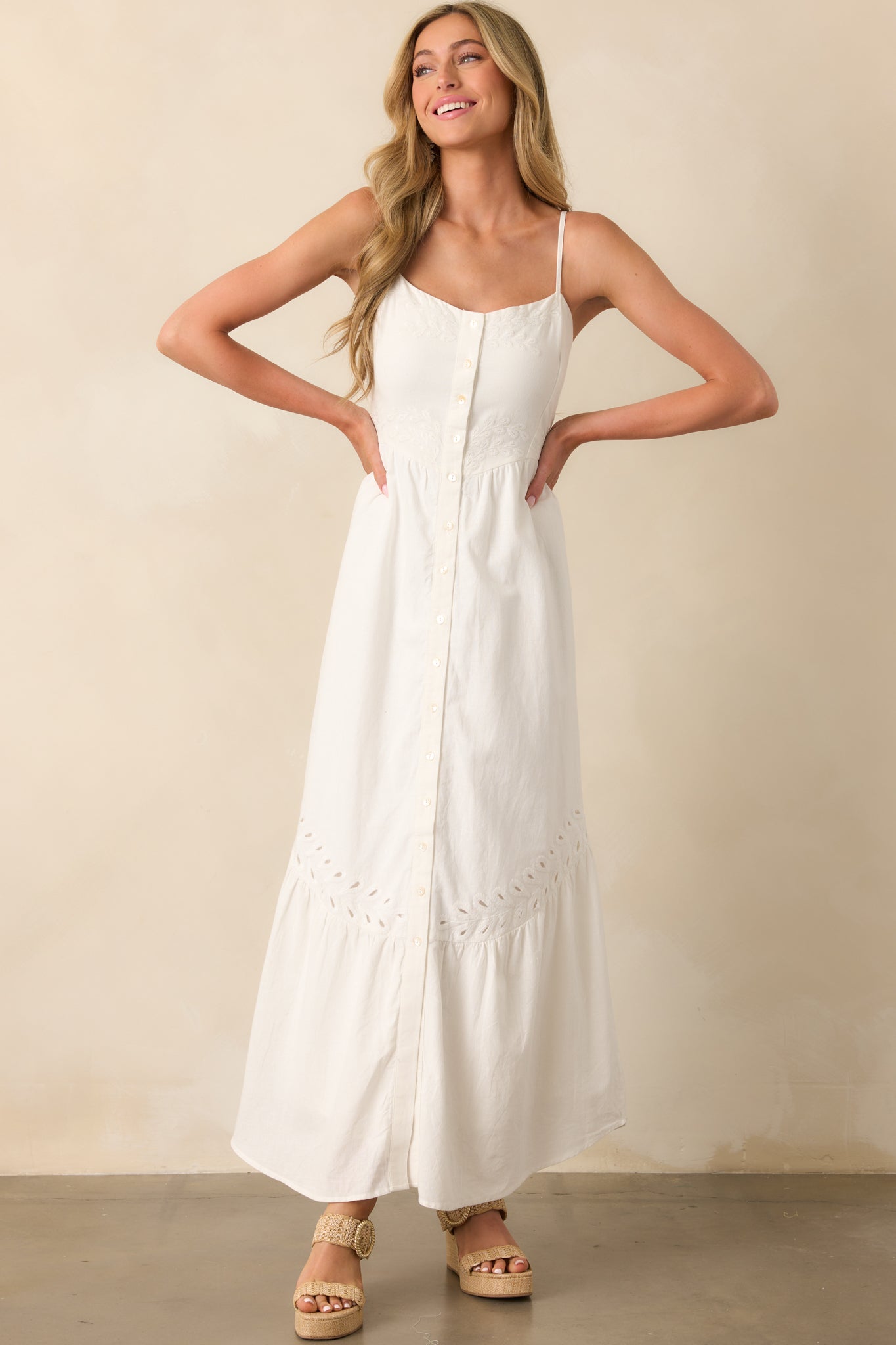Feminine white dress with a scoop neck, embroidered texture, and a subtle flare from the waist down.