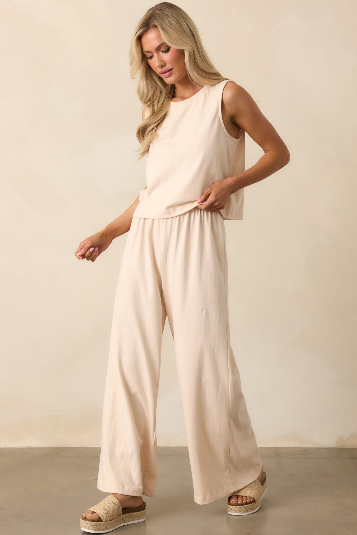 Full view of beige wide-leg pants with a relaxed fit and high-rise waist.