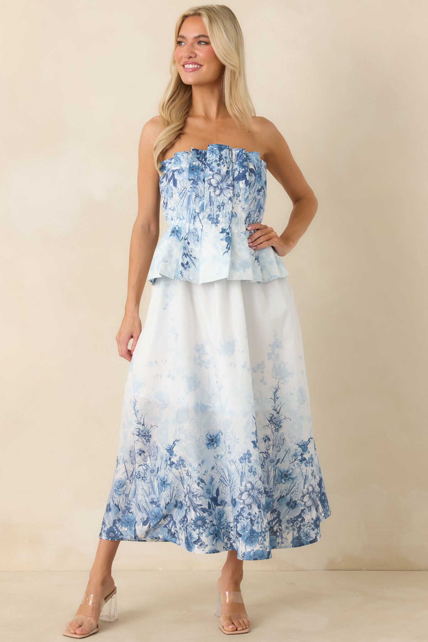 Strapless blue floral midi dress featuring pleated front and soft, flowing silhouette.
