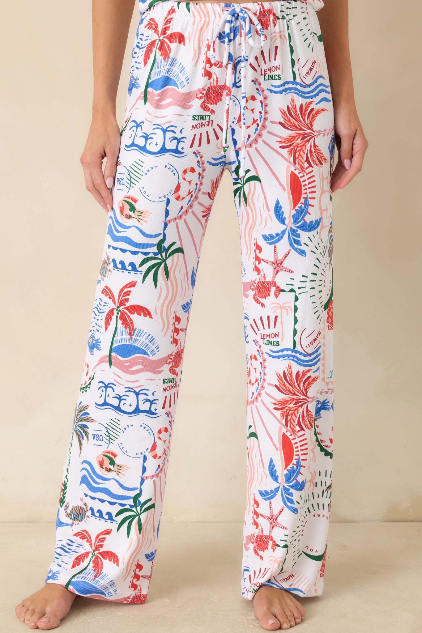 White multi print pajama pants with vibrant tropical motifs and gathered elastic waistband with drawstring tie.