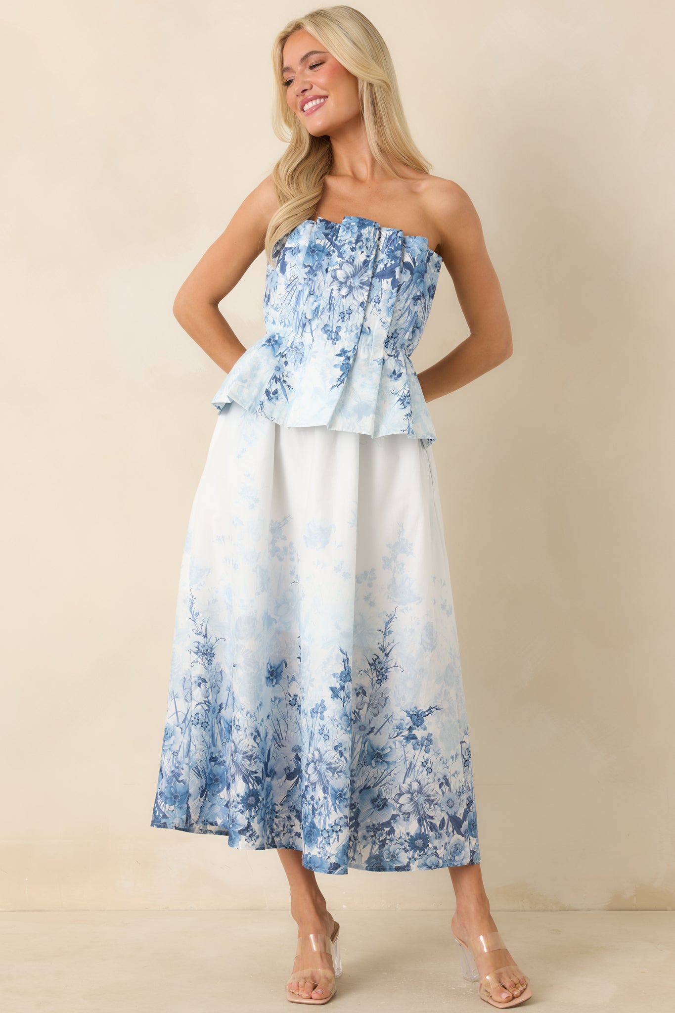 Strapless cotton midi dress in blue floral print with a fitted waist and airy drape.