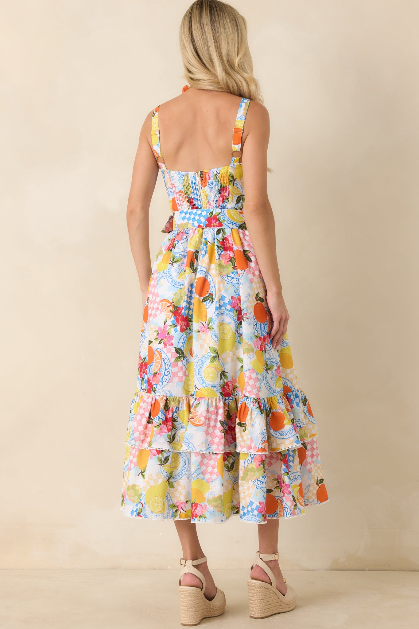 Back view of the midi dress highlighting the smocked panel, adjustable straps, and continuous citrus print across the full silhouette.