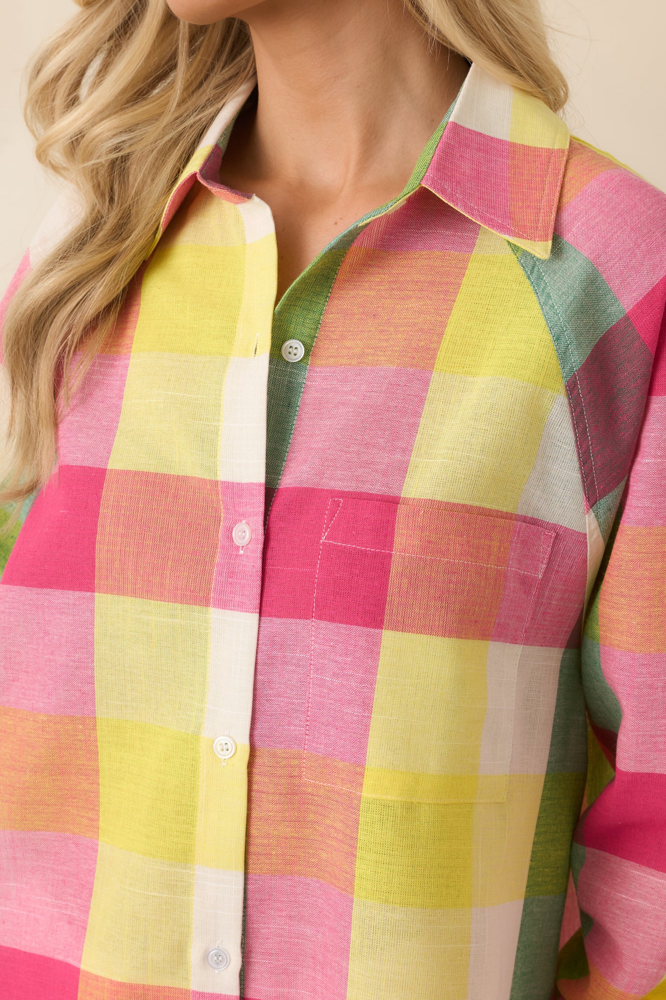 Close-up of the pink multi plaid fabric highlighting the lightweight cotton weave, colorful plaid pattern, and button-front construction.