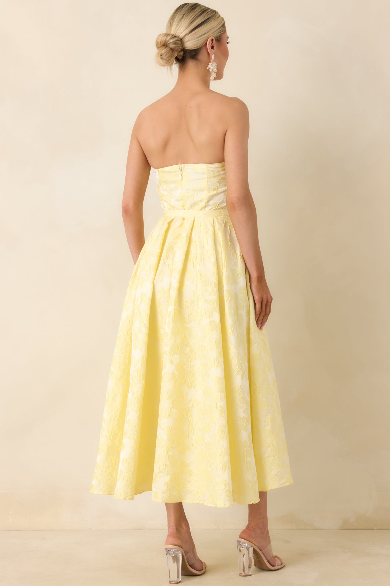 Rear view of strapless midi dress, with smooth silhouette and concealed zipper closure.