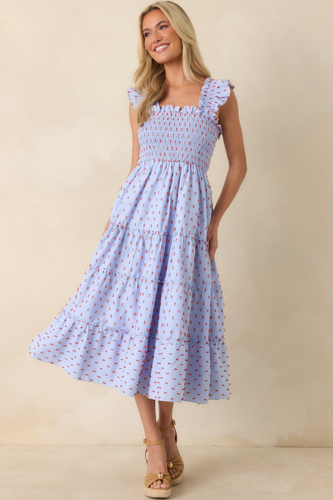 Blue checkered midi dress showcasing textured smocking, embroidered accents, and a breezy tiered design.