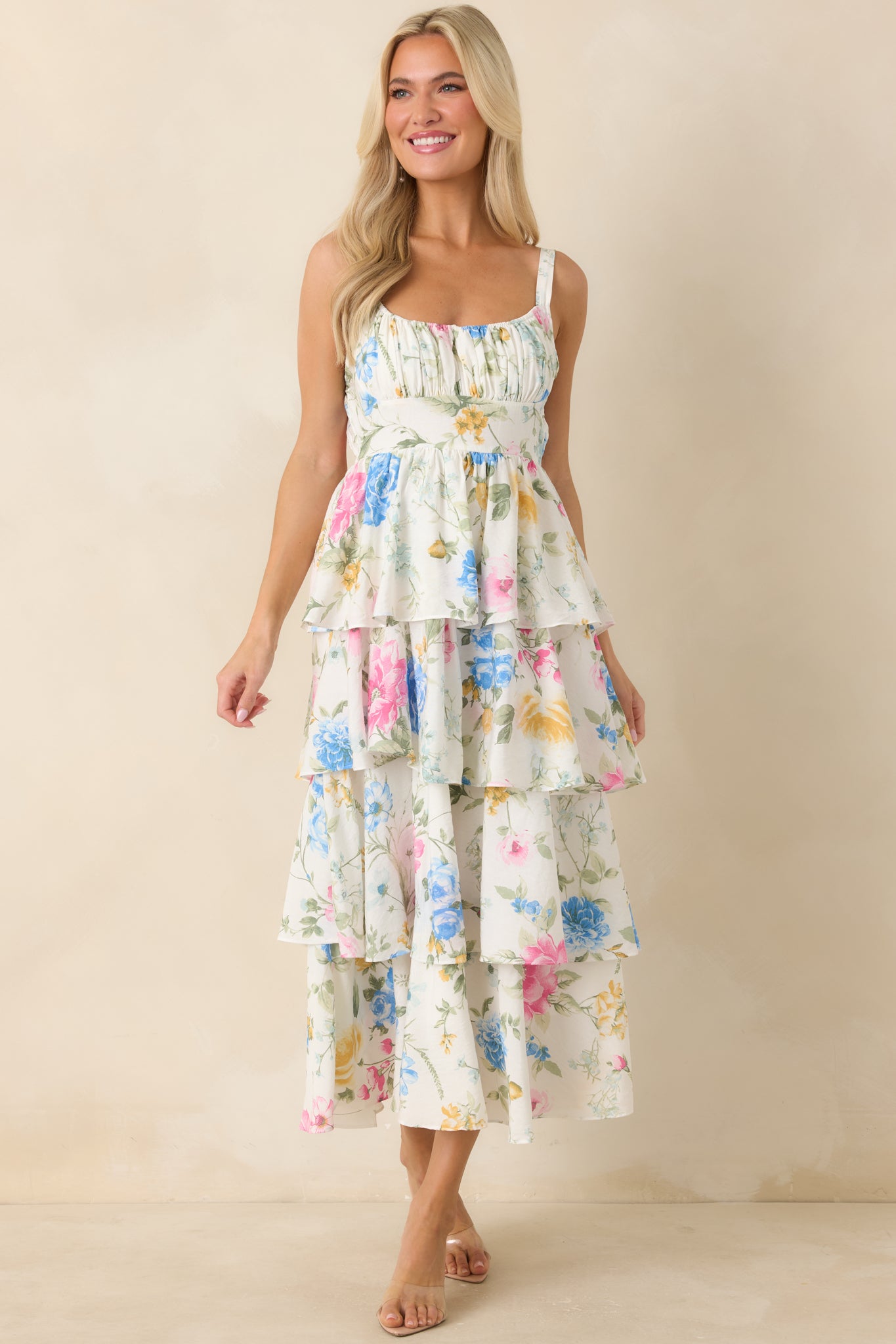 Floral maxi dress with gathered bust, adjustable shoulder straps, and a flowing tiered silhouette.