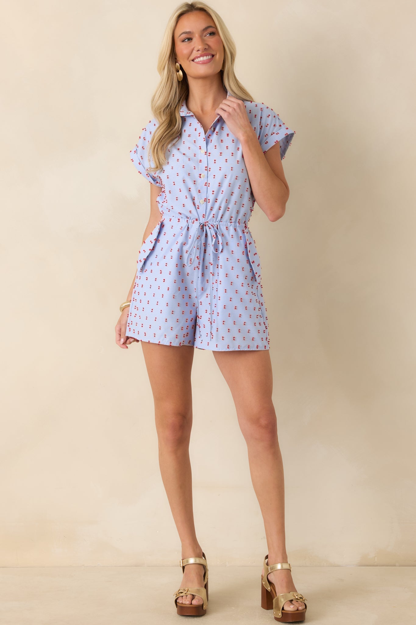 Lightweight cotton romper with a button-front bodice, rolled cap sleeves, and an elastic drawstring waist.