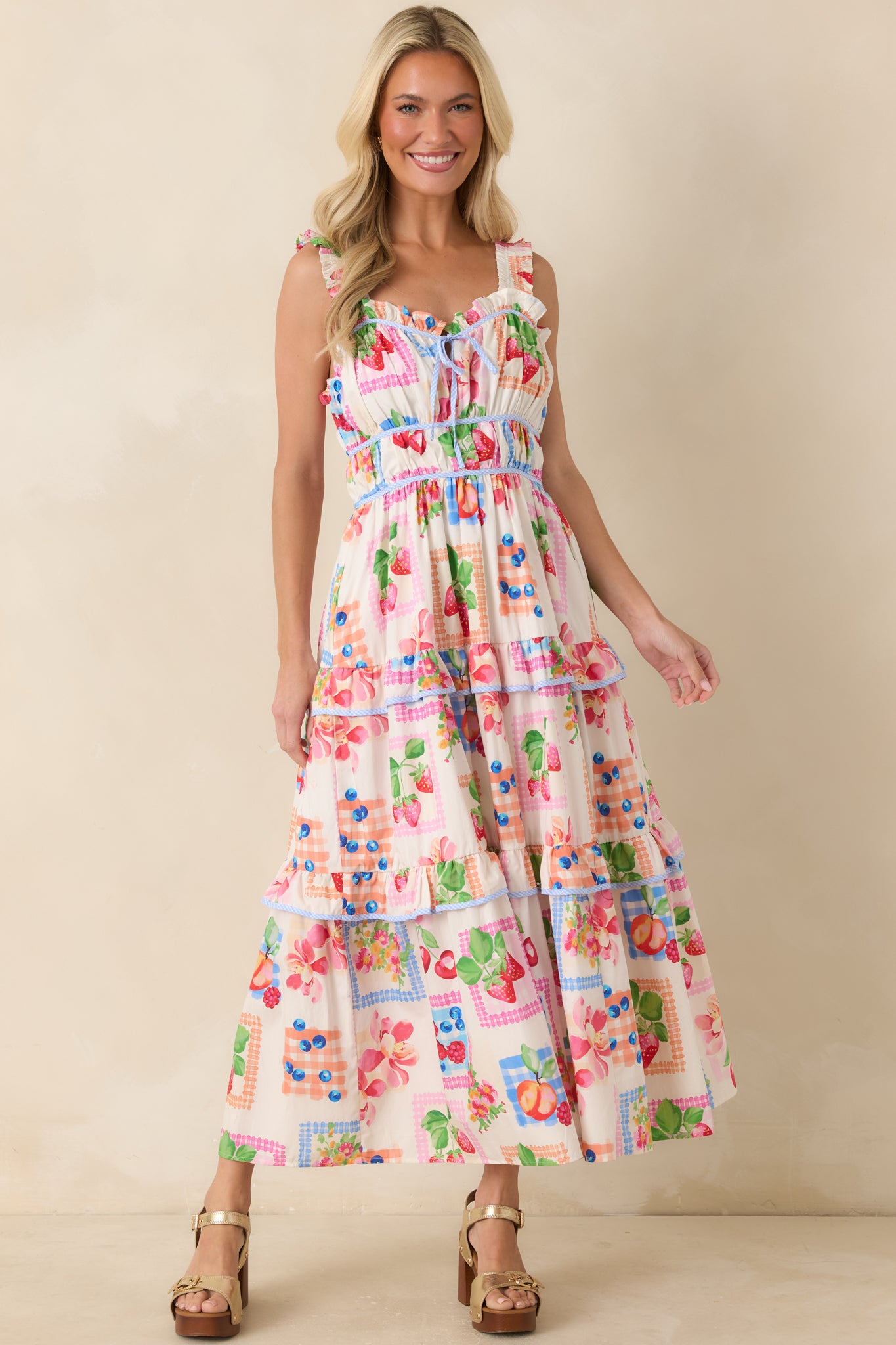 Lightweight cotton maxi dress with contrasting blue gingham trim, a fitted bodice, and a flowing tiered skirt silhouette.