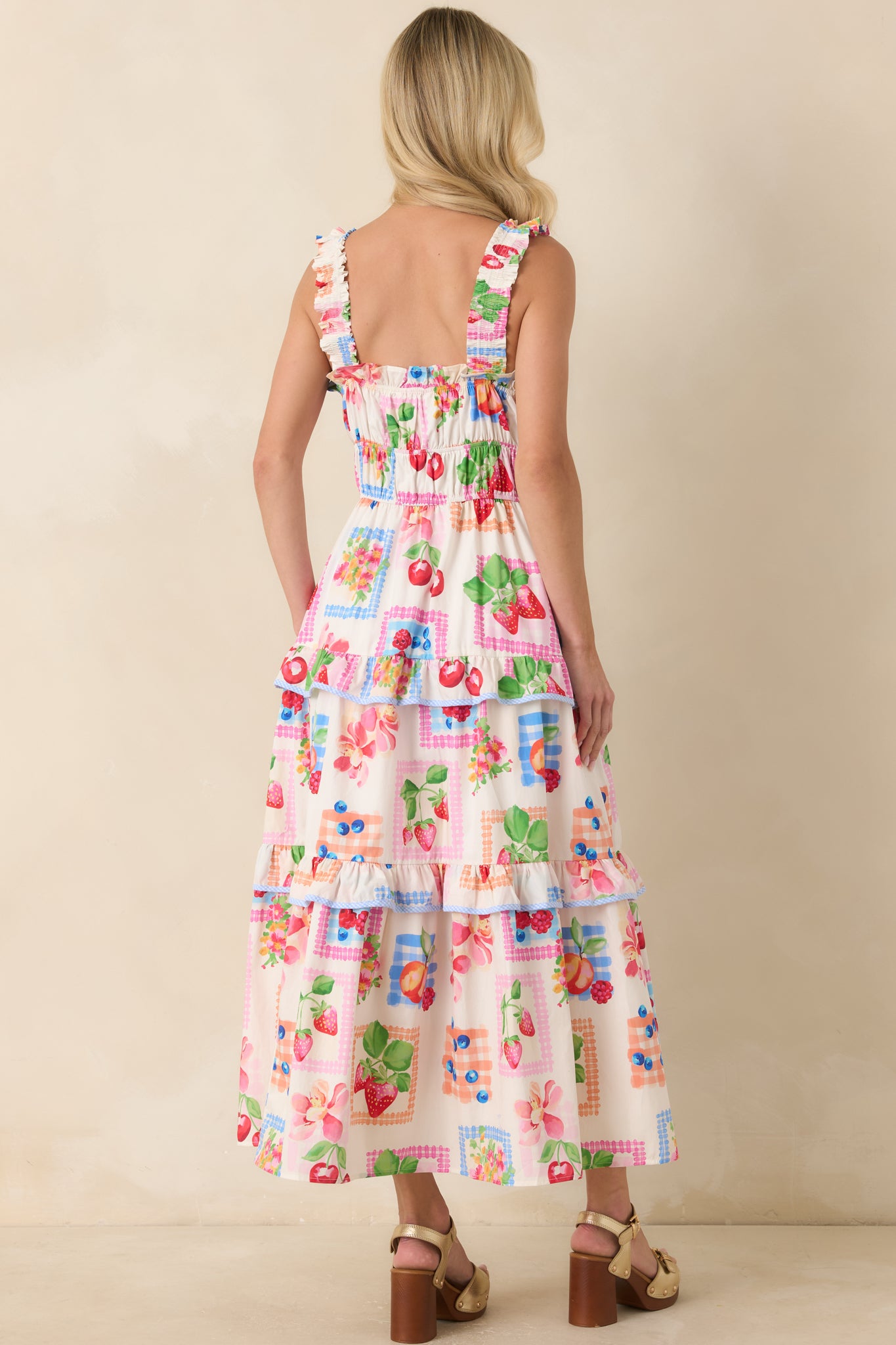 Back view of the maxi dress featuring a smocked panel, ruffled shoulder straps, and a flowing tiered skirt silhouette.