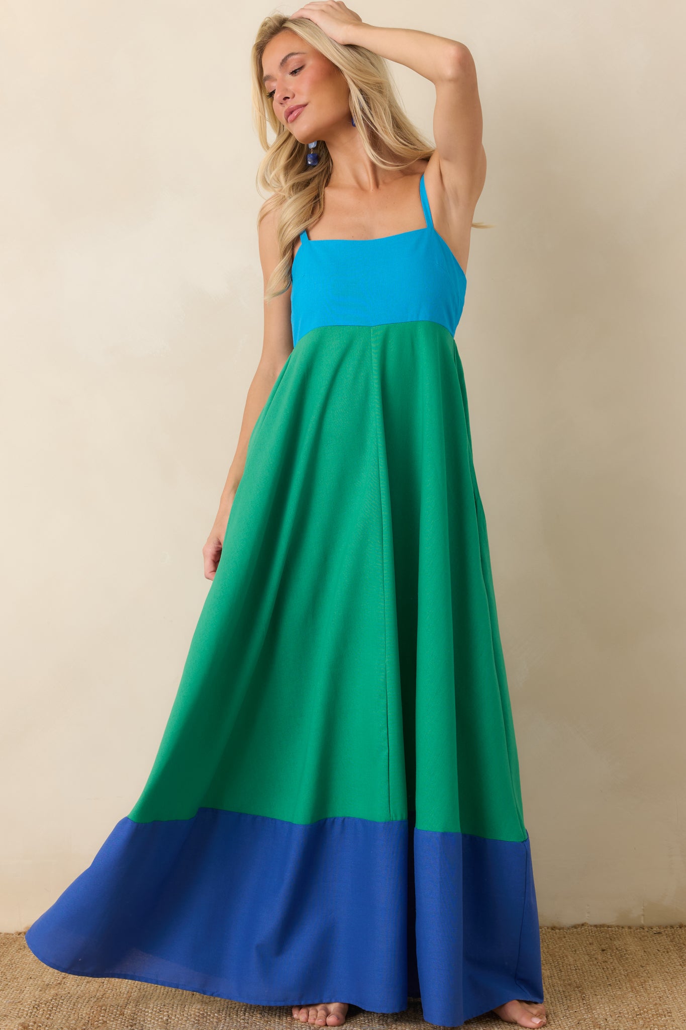 Green and blue color block maxi dress featuring a square neckline, adjustable shoulder straps, a smocked back bodice, and a flowing full-length skirt with a contrasting hemline.