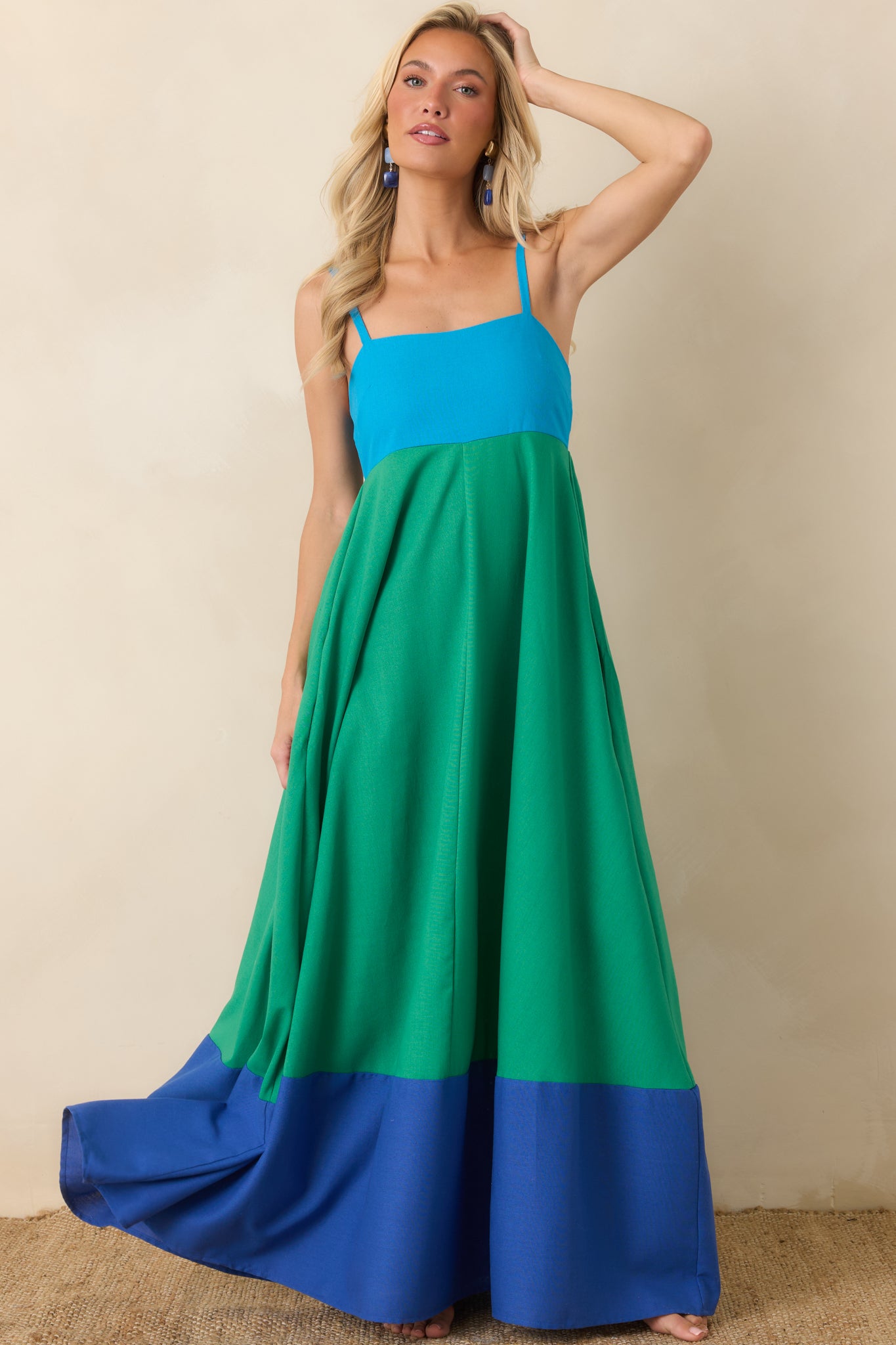 Green and blue color block maxi dress featuring a square neckline, adjustable straps, and a flowing linen blend skirt with a contrasting blue hem.
