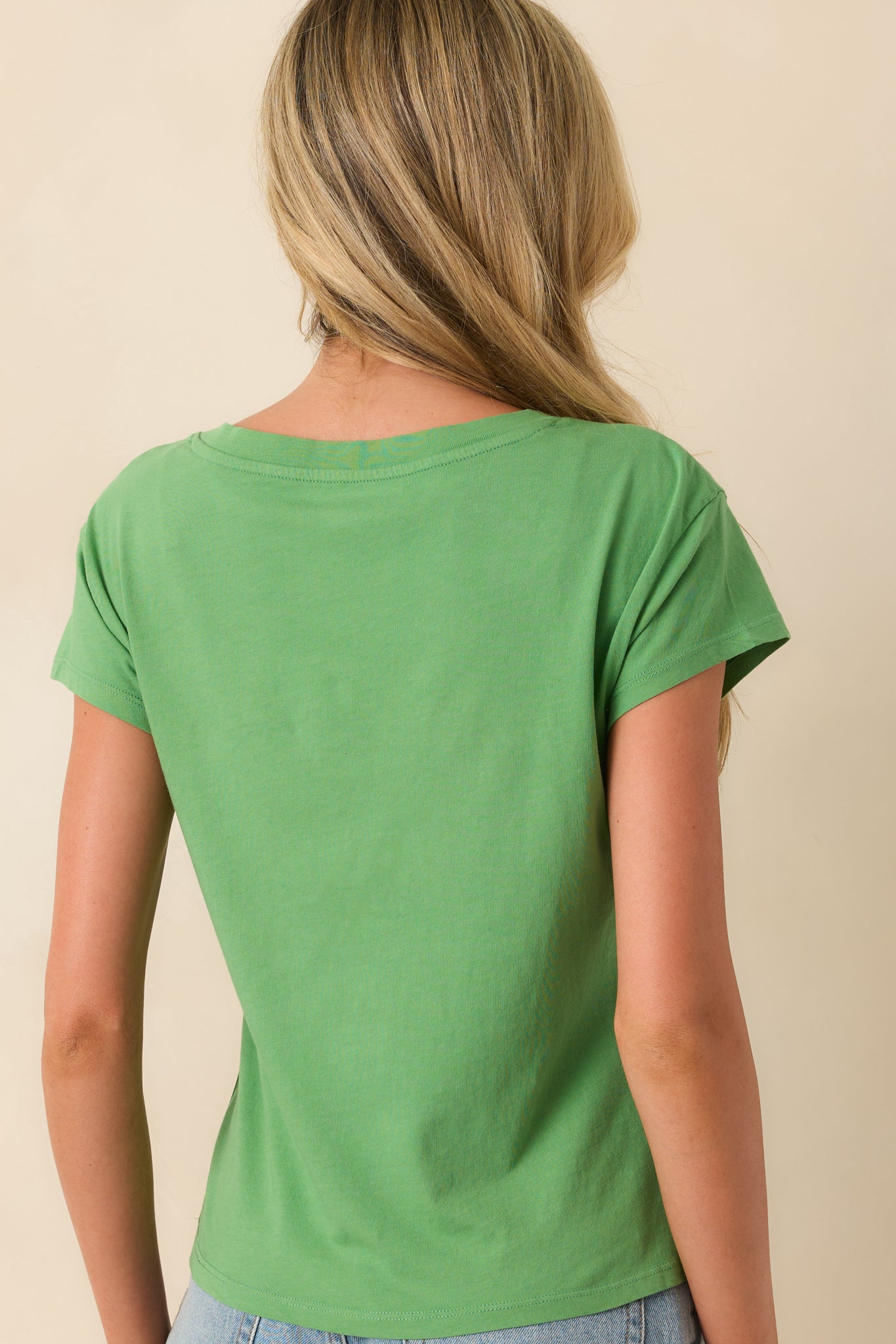 Rear view of the green tee showing the straight hem and relaxed fit across the back.
