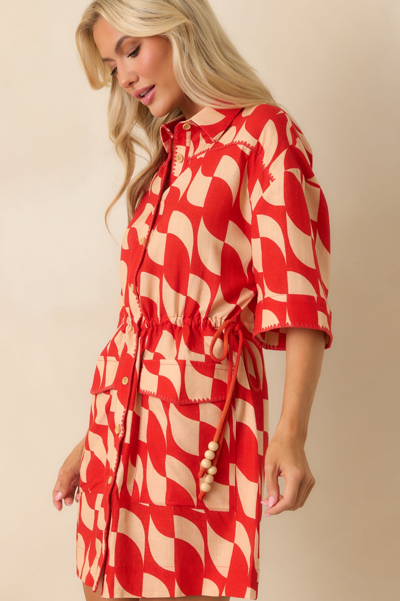 Cropped view of one side showing the drawstring waist tie with tassels and subtle embroidery detail.