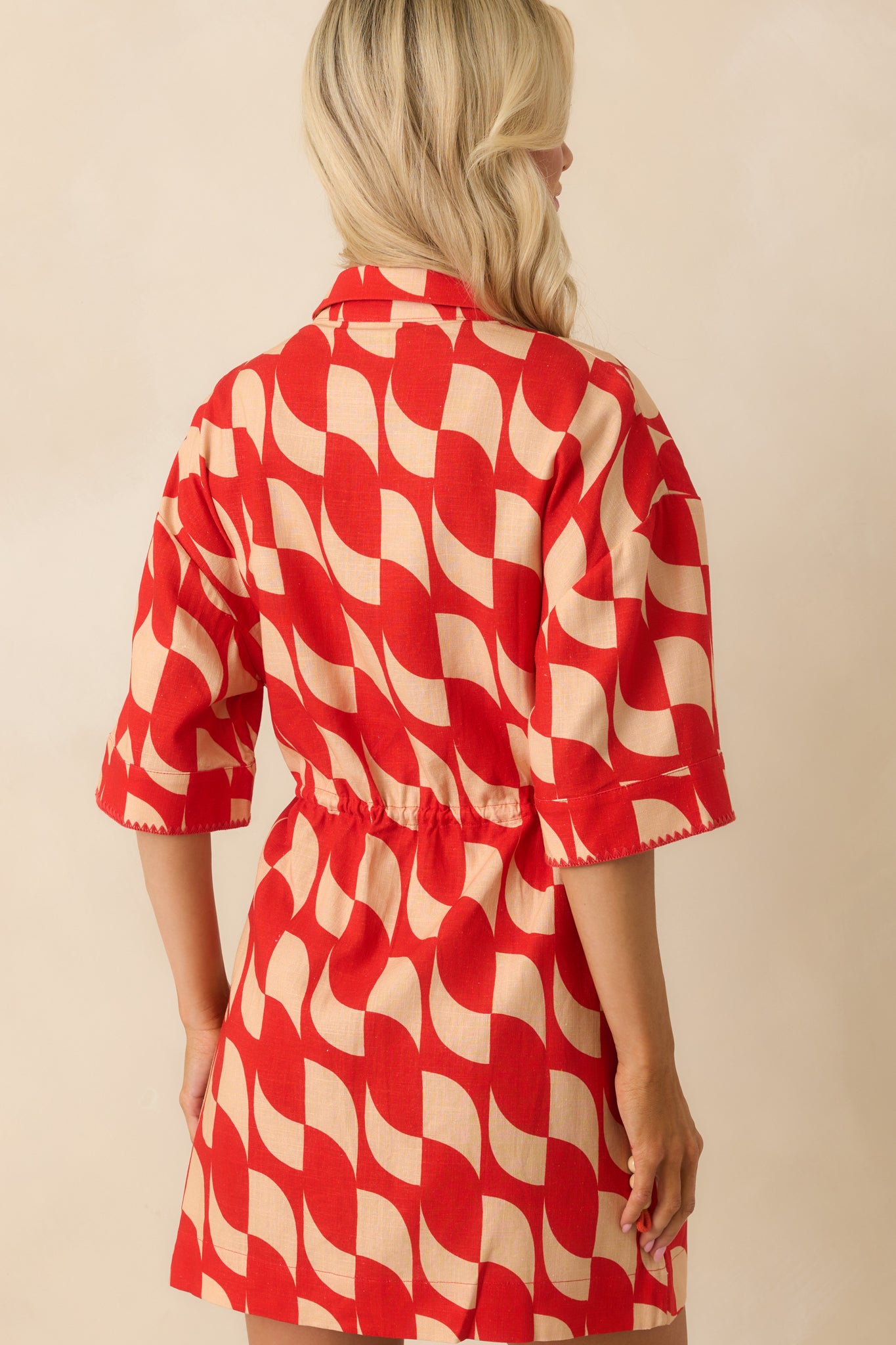 A view from behind showing the continuous abstract geometric print and relaxed shape of the mini dress.