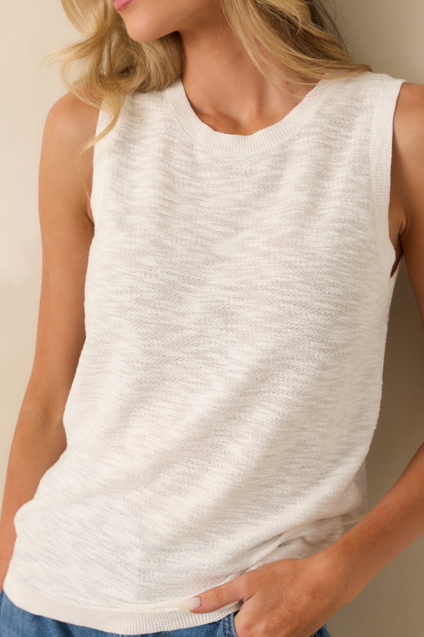 A cropped front waist-up shot emphasizing the ribbed hemline and the drape of the light fabric.