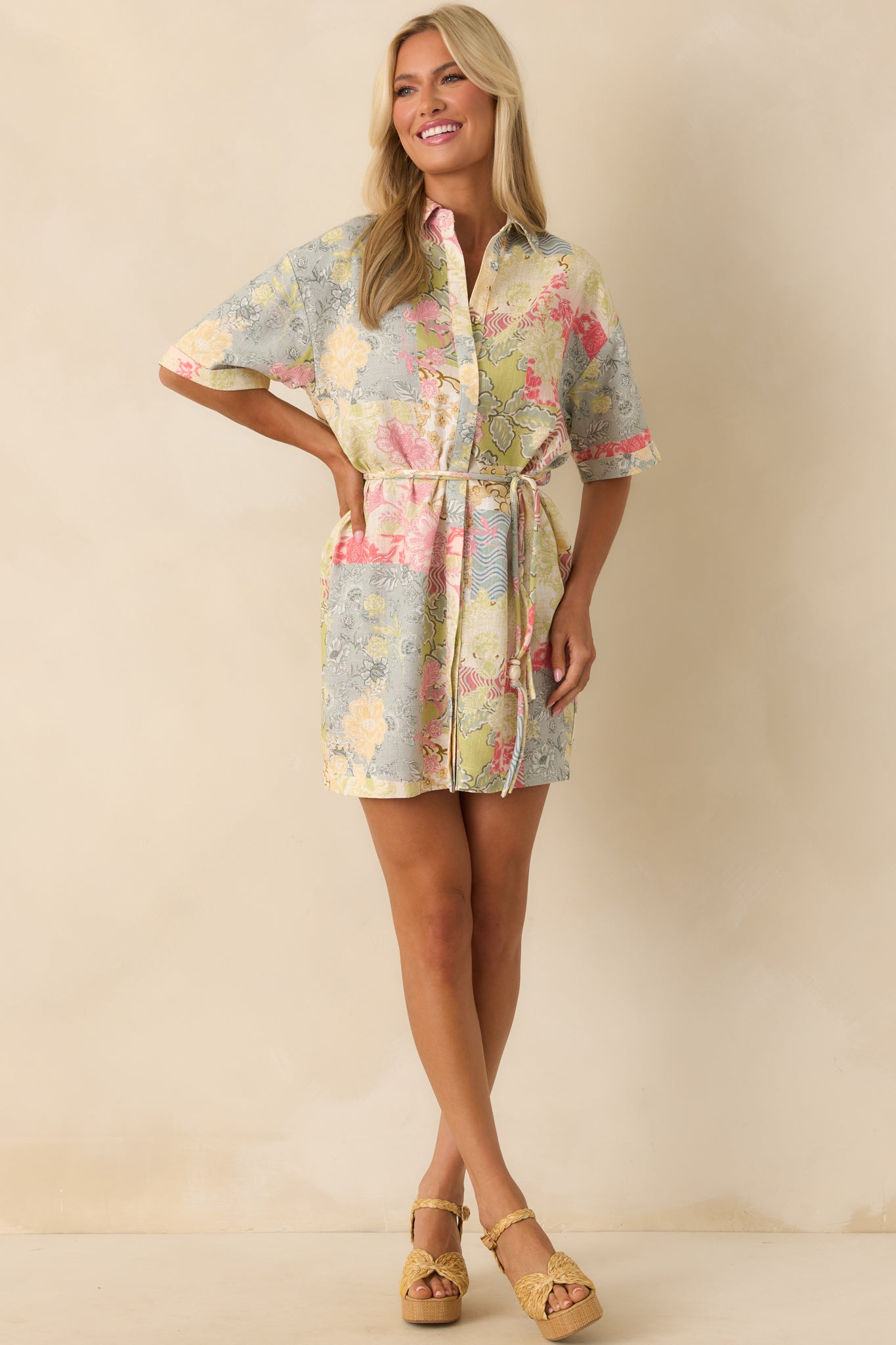 A full body front view showing the mini dress with its multicolor patchwork print, collared neckline, and optional self-tie belt cinching the waist.