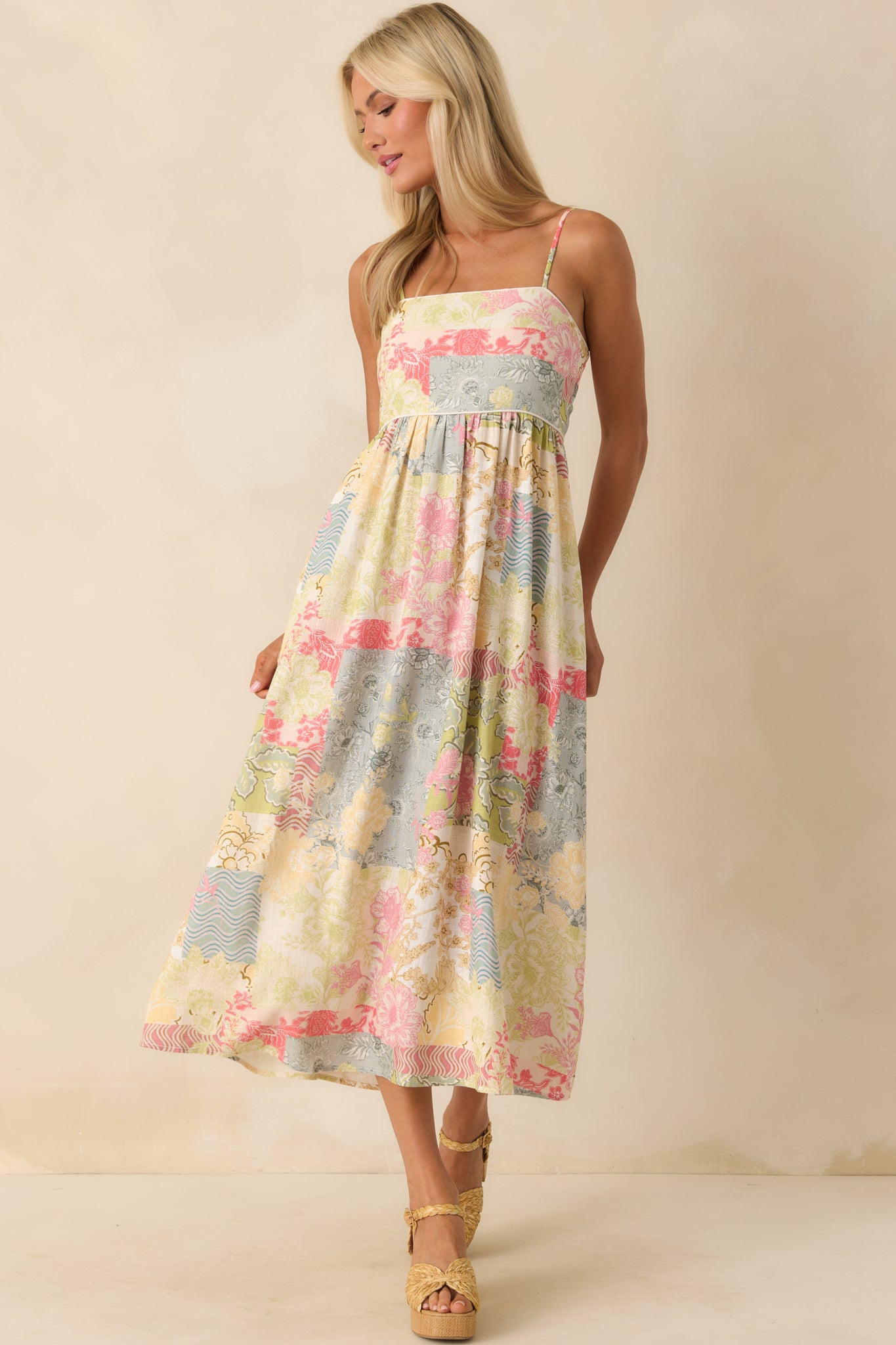 Front-facing full shot highlighting the adjustable spaghetti straps, fitted bodice, and flowing skirt with patchwork detailing.