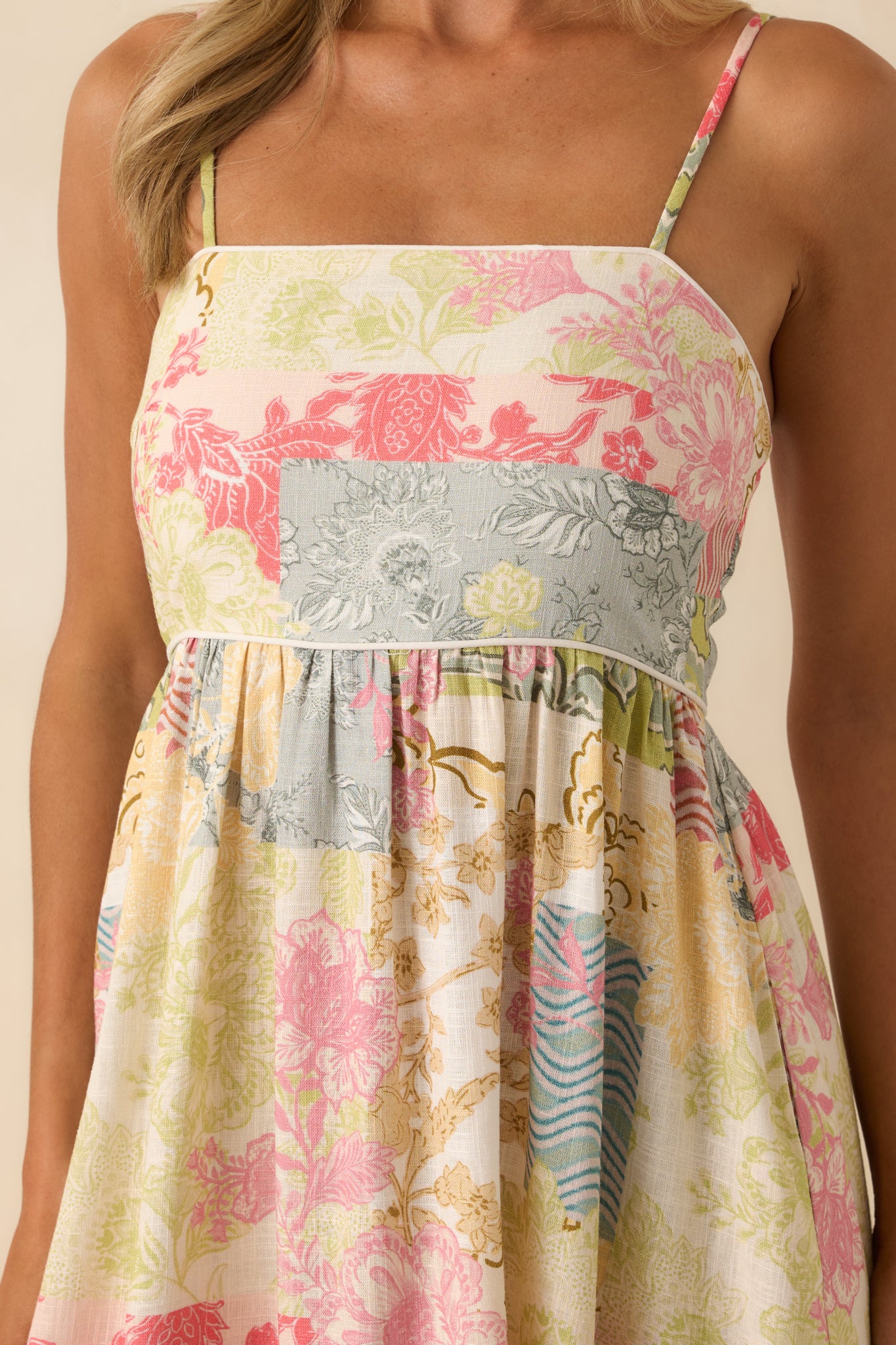 Extreme close-up of the patchwork print and ivory piping, showing the stitching and mix of fabric patterns and colors.