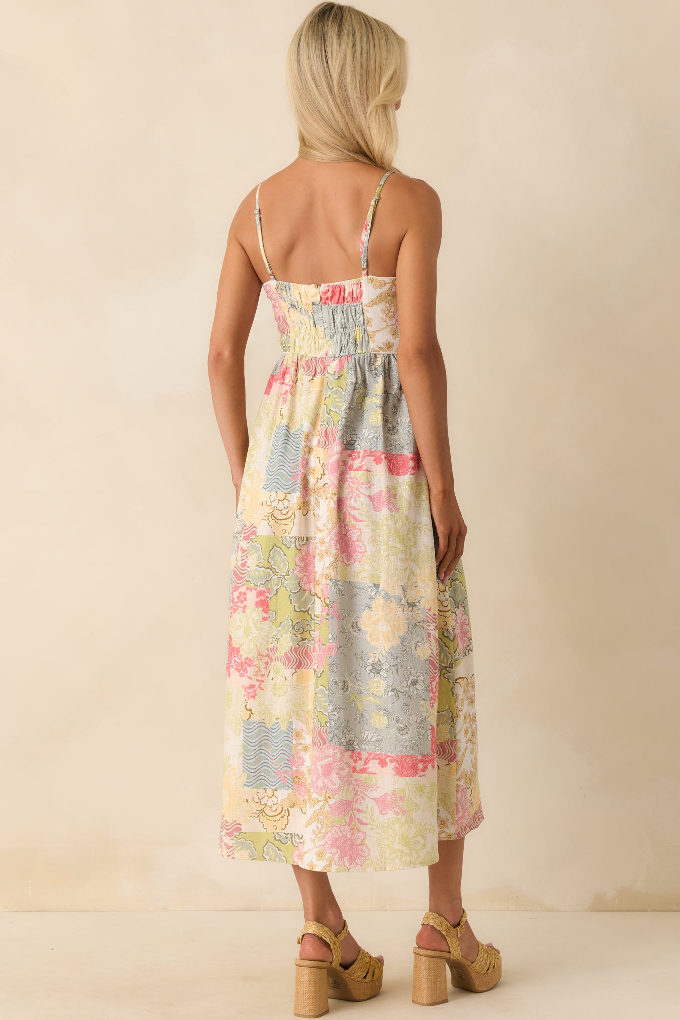 Back view of the dress featuring the smocked elastic back panel, hidden zipper closure, and continuation of the patchwork print.