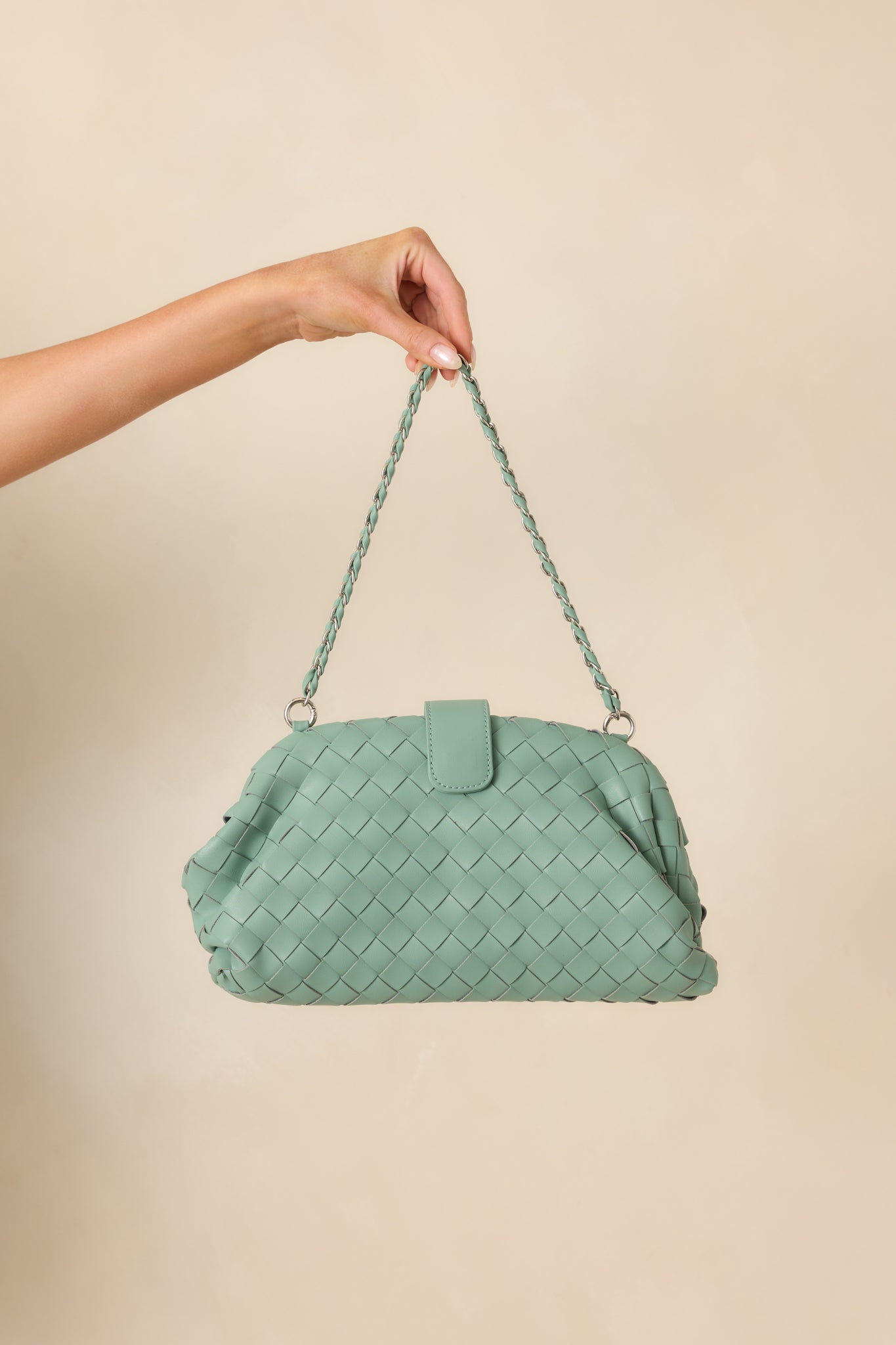 Cropped image showing the braided shoulder strap detail and muted mint green faux leather.