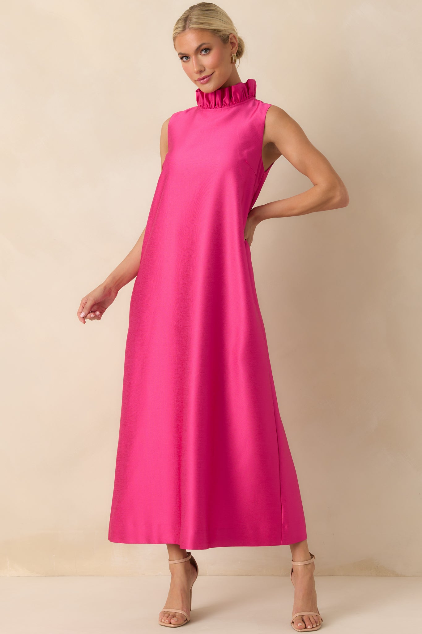 Full-length hot pink dress with ruffled mock neckline, sleeveless silhouette, and relaxed maxi-length flow.