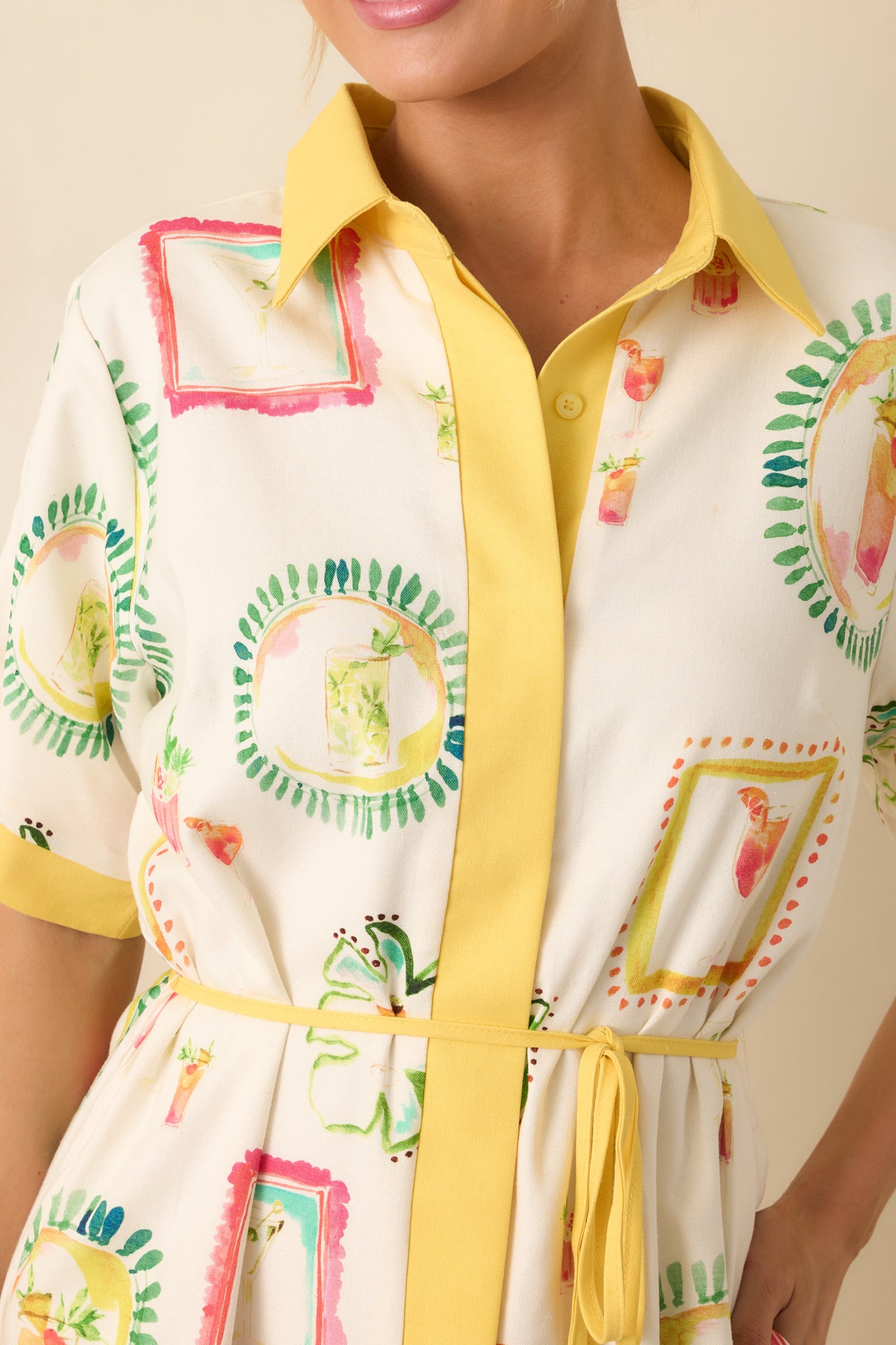 Detailed view of the yellow-covered placket and button closures framed by the watercolor patchwork print.