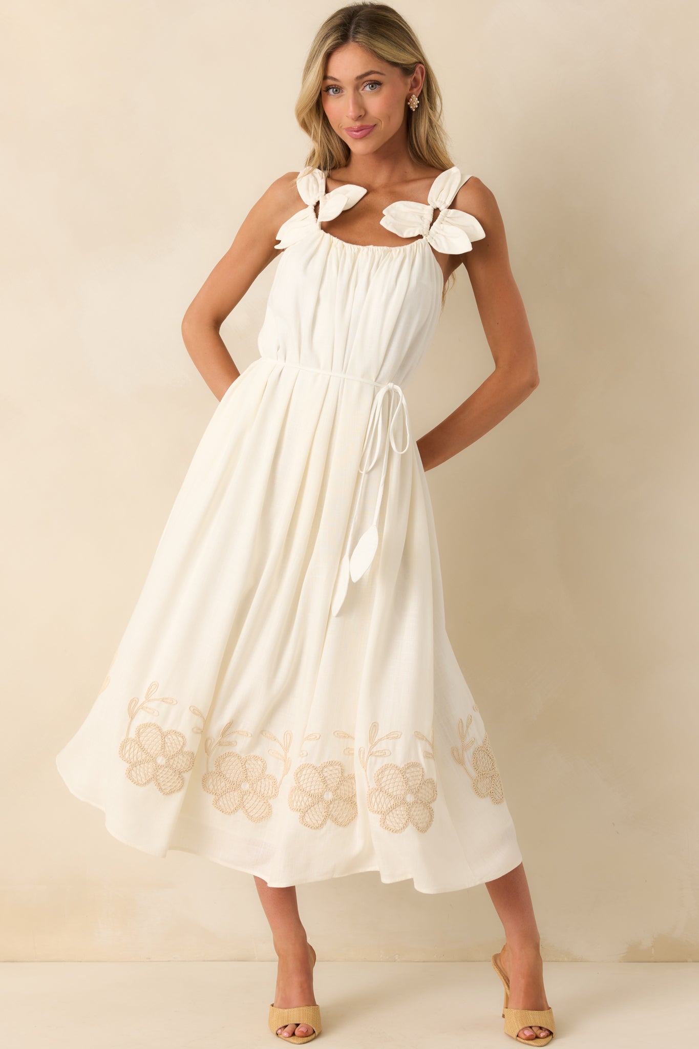 Front view showcasing the beige floral embroidery along the bottom hem and the relaxed drape of the dress.