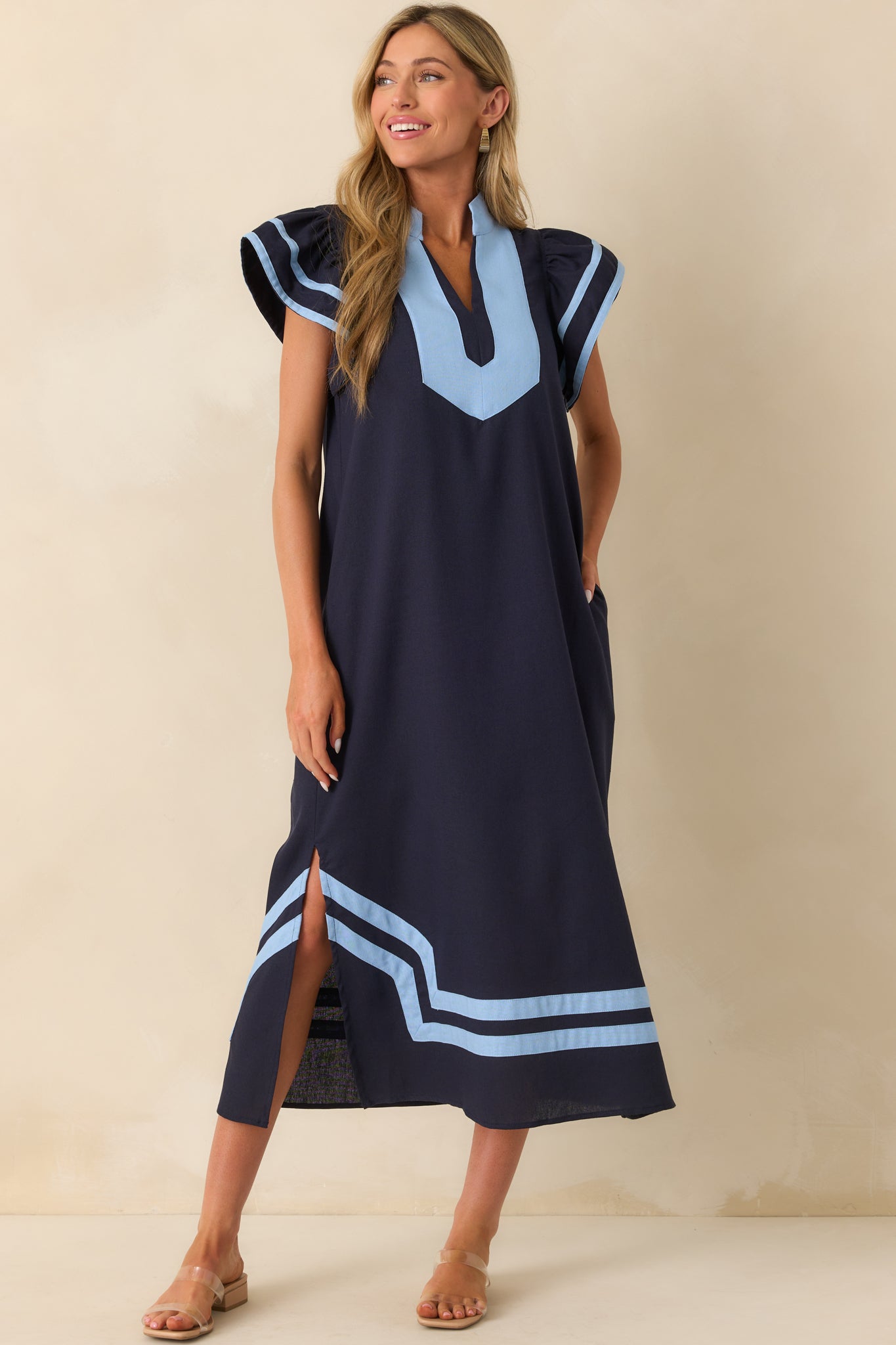Front view of the navy maxi dress highlighting the notch v-neckline, short flutter sleeves, and soft drape of the fabric.