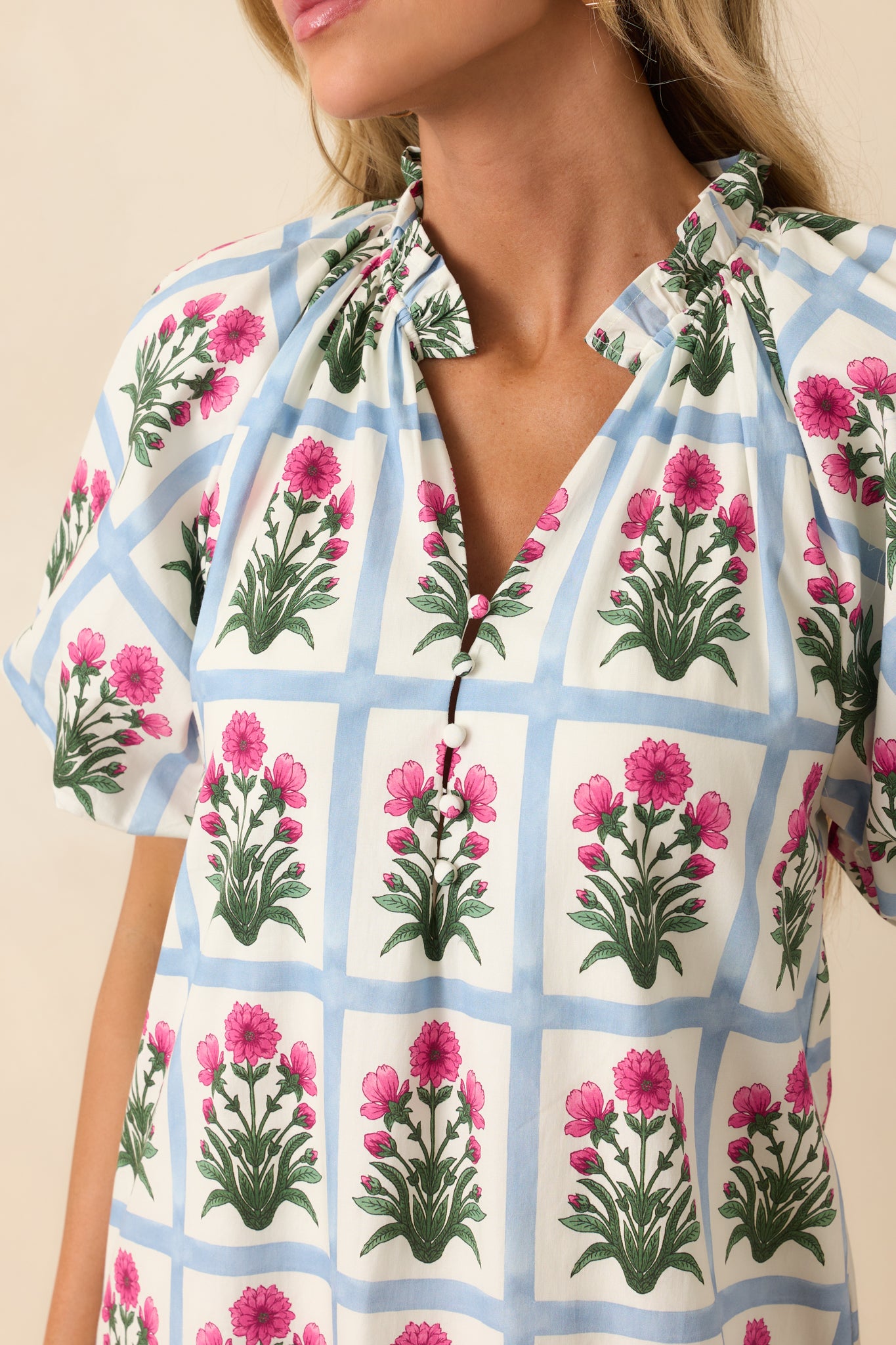 Detail view of the fabric showing the contrast between the light blue grid and dark fuchsia floral motifs with fine stitching.