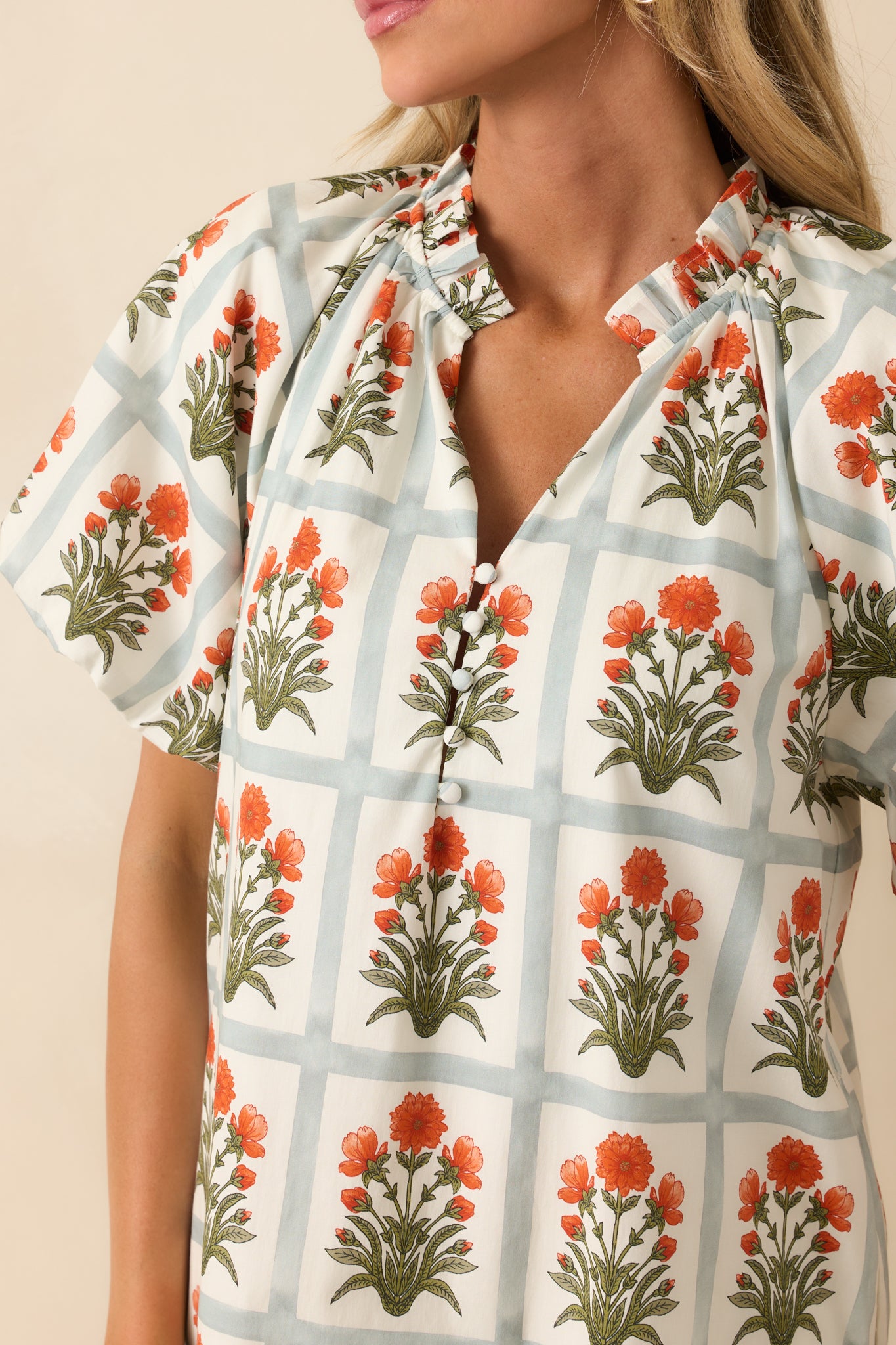 Detailed view of the functional button front at the bust with crisp floral motif and ruffled trim finishing.