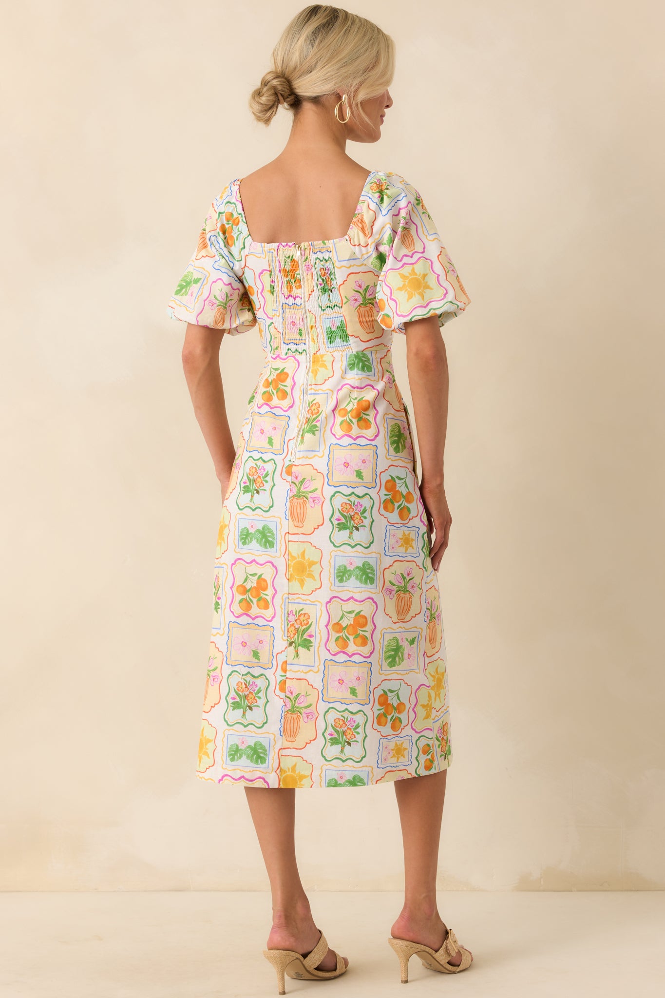 View from behind displaying the smocked back panel, back zipper closure, and continued patchwork print across the back of the dress.